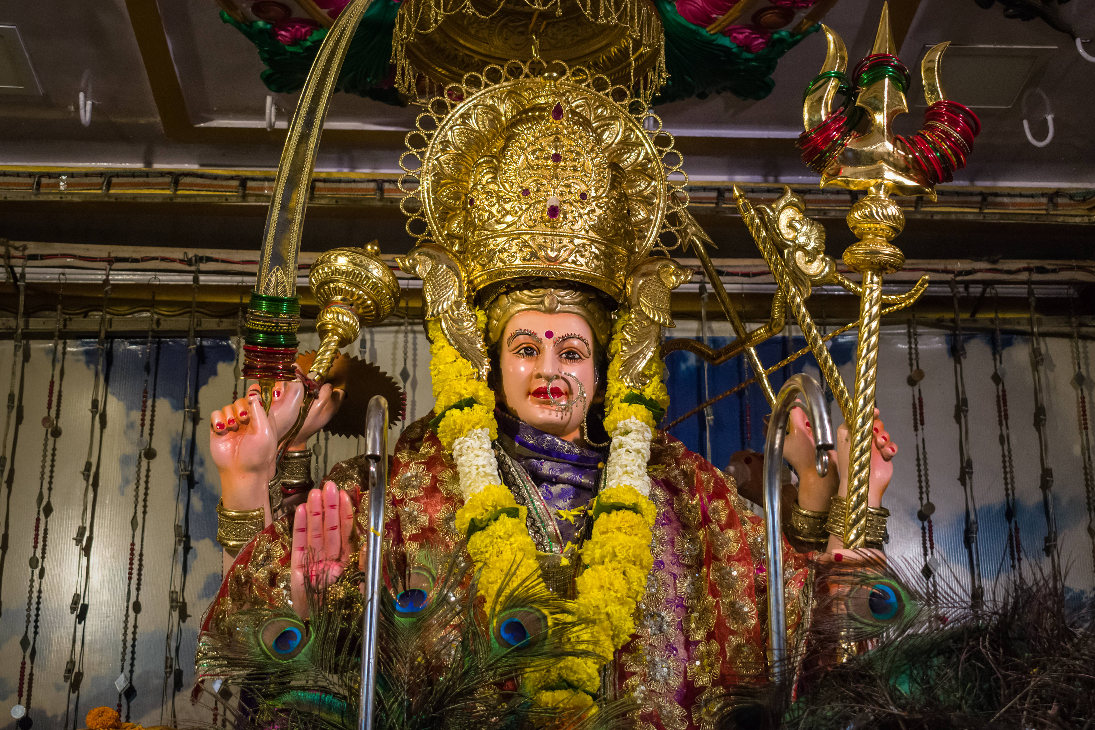 Ambe Maa, yellow marigold garlands, peacock feathers, 2K Desktop Wallpaper