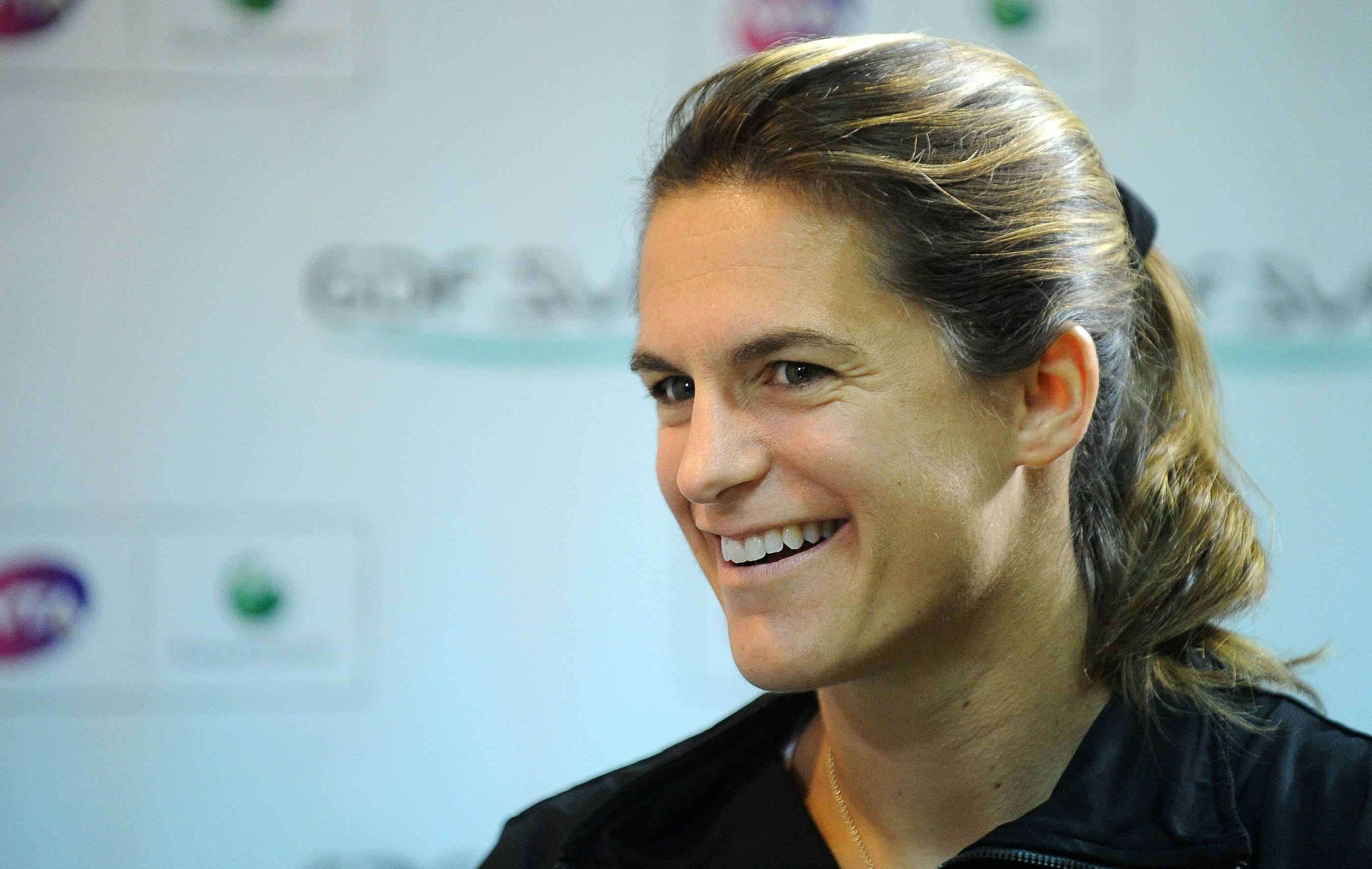 Amélie Mauresmo, black jacket, long hair tied back, 2K Desktop Wallpaper