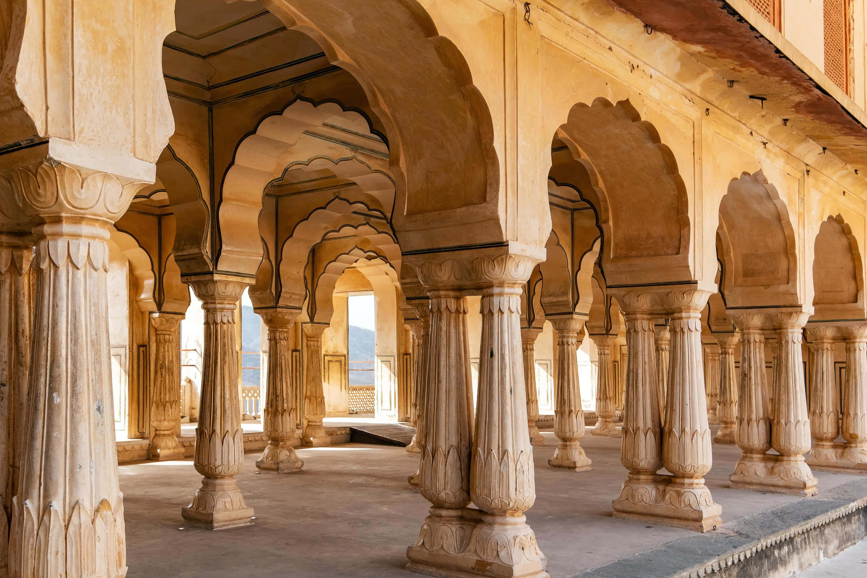 Amer Fort, long colonnade, intricately carved stone pillars, 2K Desktop Wallpaper