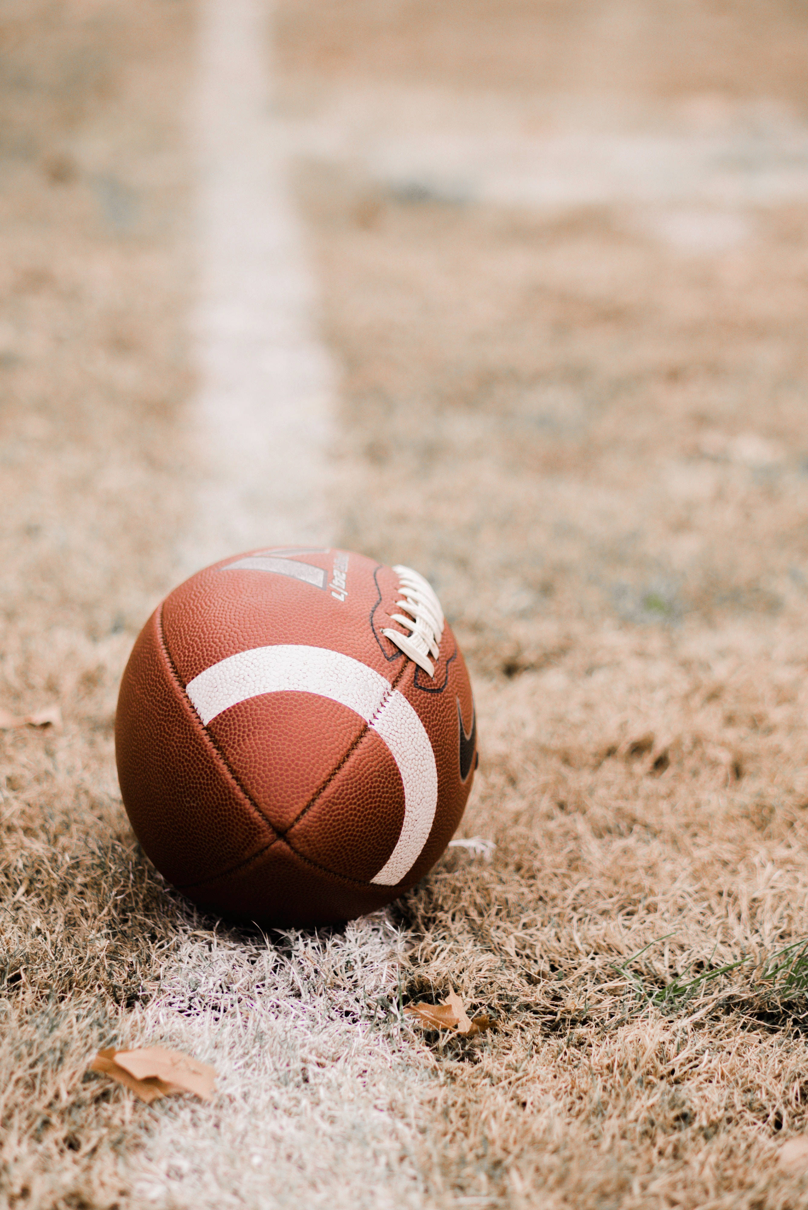 brown leather football, dry grass, white yard line, 4K Phone Wallpaper