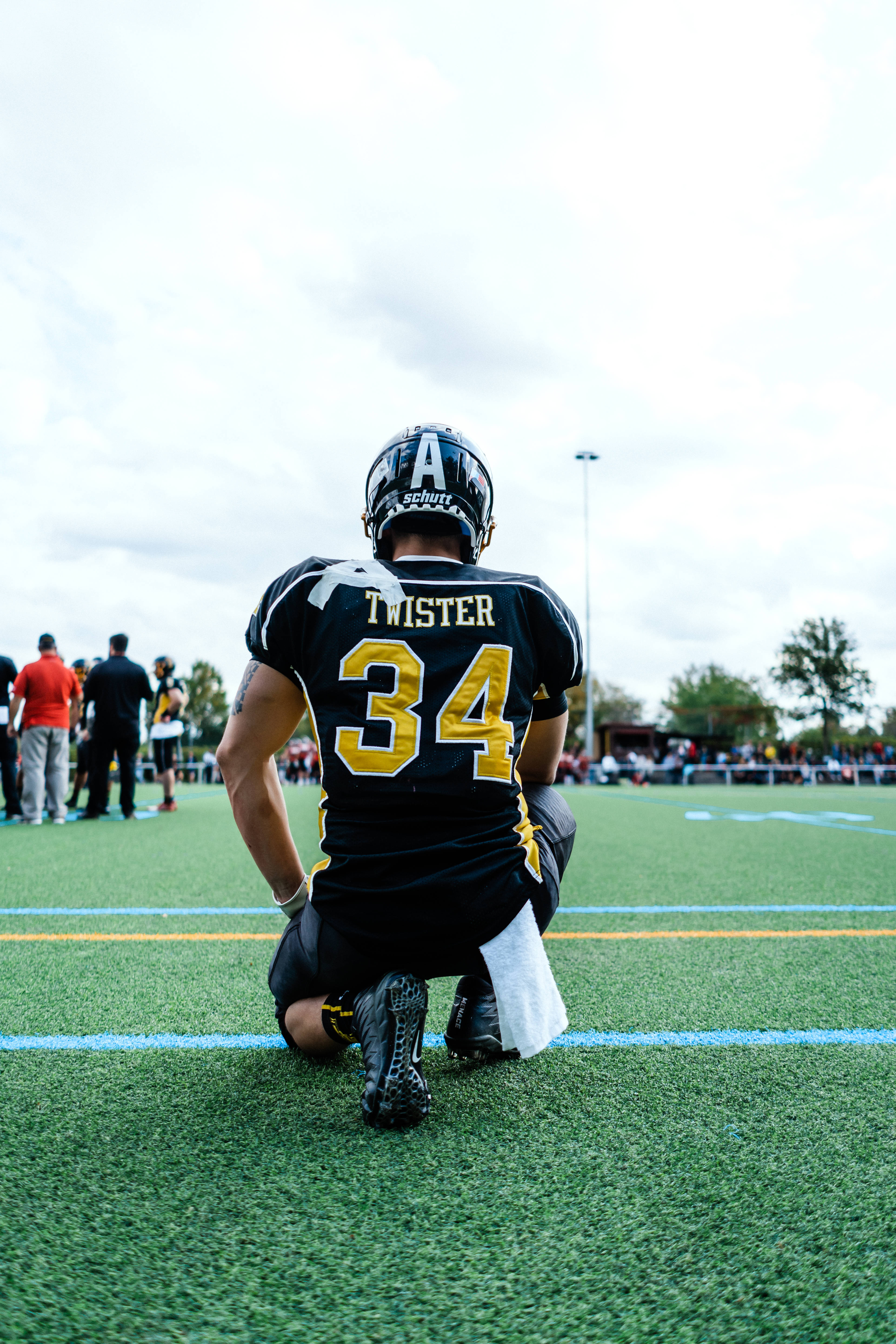 American Football, black and gold jersey, green turf field, 5K Phone Wallpaper