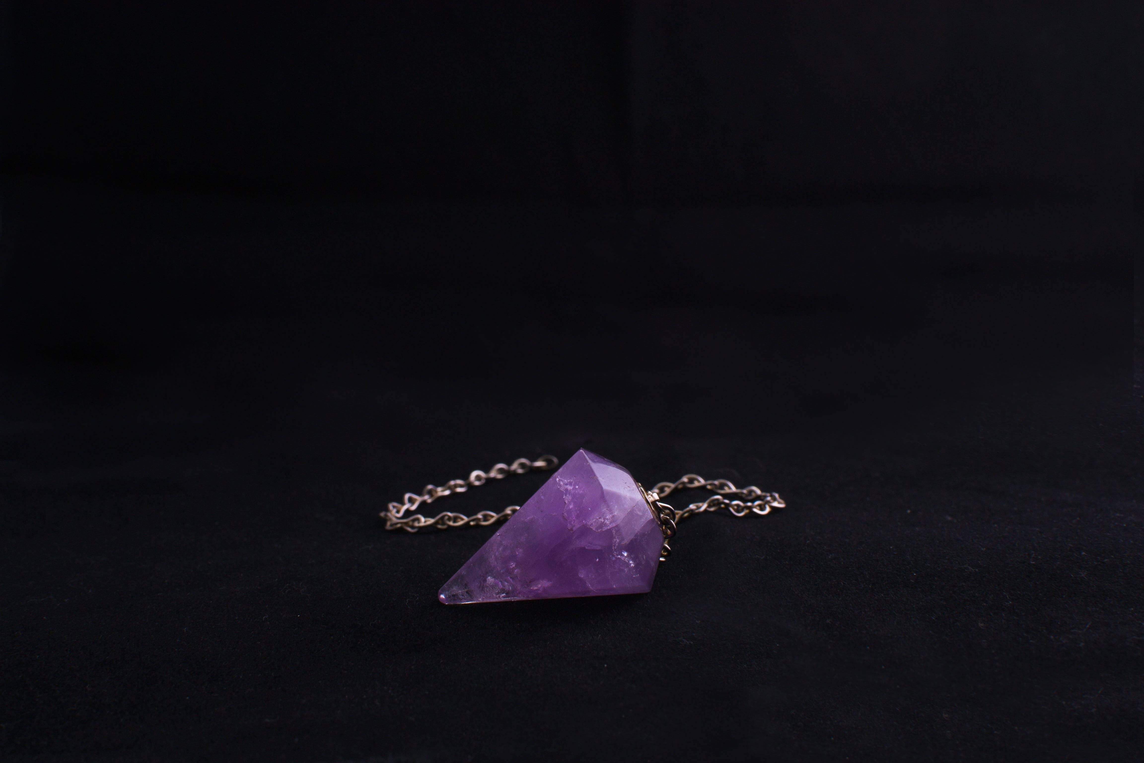 amethyst pendulum, faceted purple amethyst, black velvet surface, 4K Desktop Wallpaper