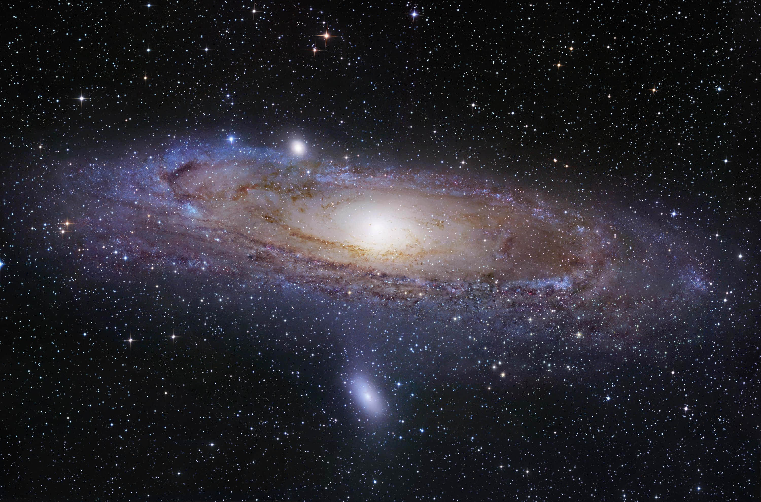 Andromeda Galaxy, golden and blue hues, star-studded cosmic backdrop, 2K Desktop Wallpaper