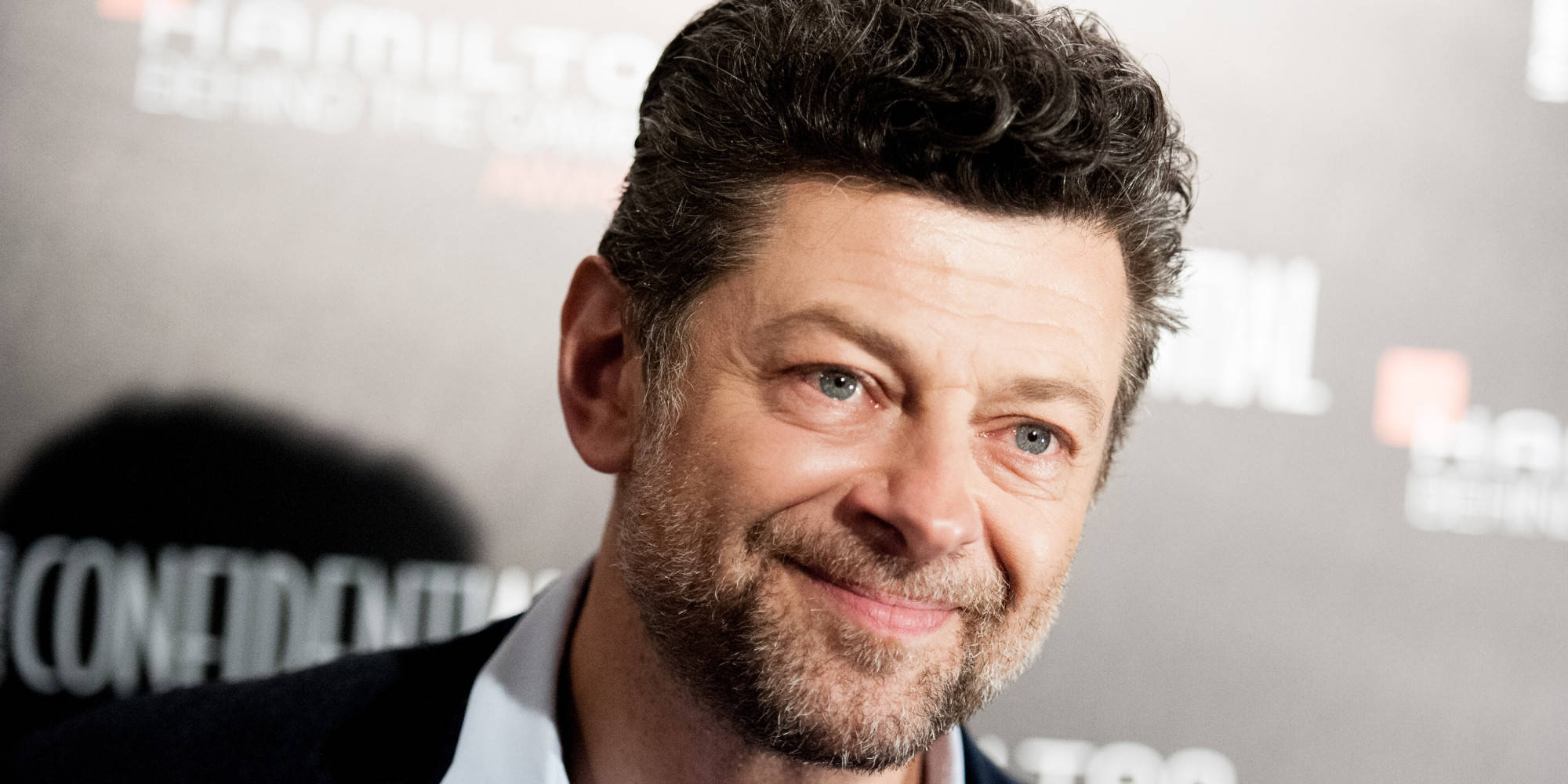 Andy Serkis, branded event backdrop, smiles warmly, Full HD Desktop Wallpaper