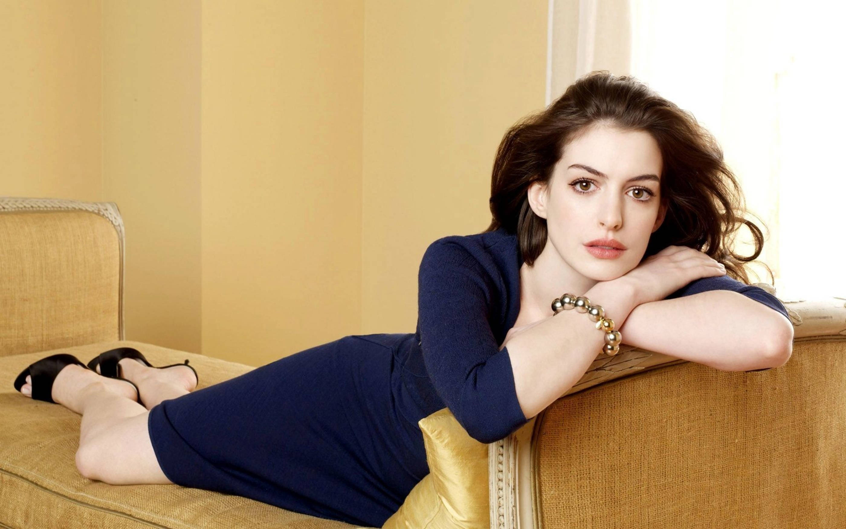 Anne Hathaway, navy dress, golden sofa, 2K Desktop Wallpaper