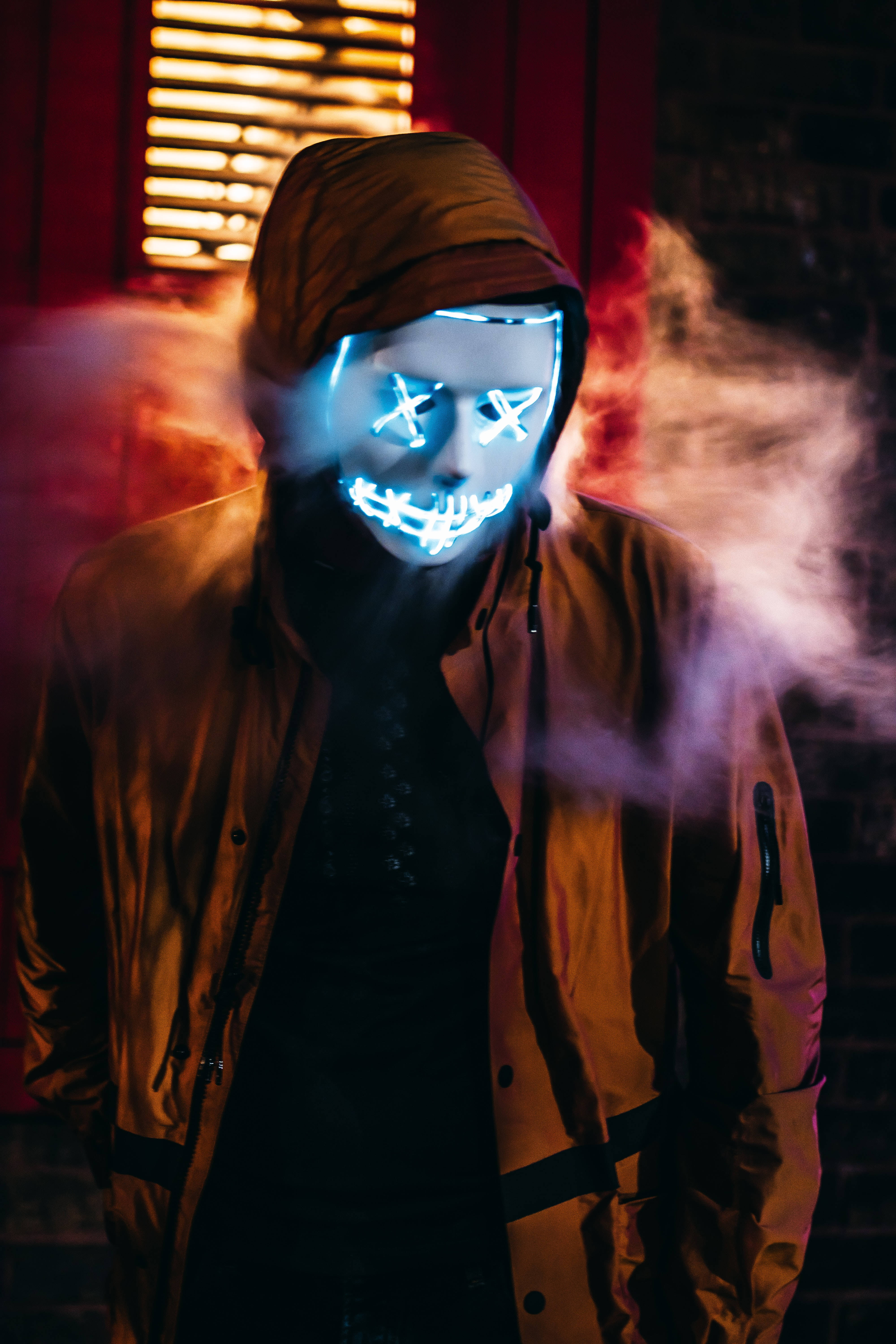 glowing blue LED mask, hooded jacket, smoky dim light, 5K Phone Wallpaper