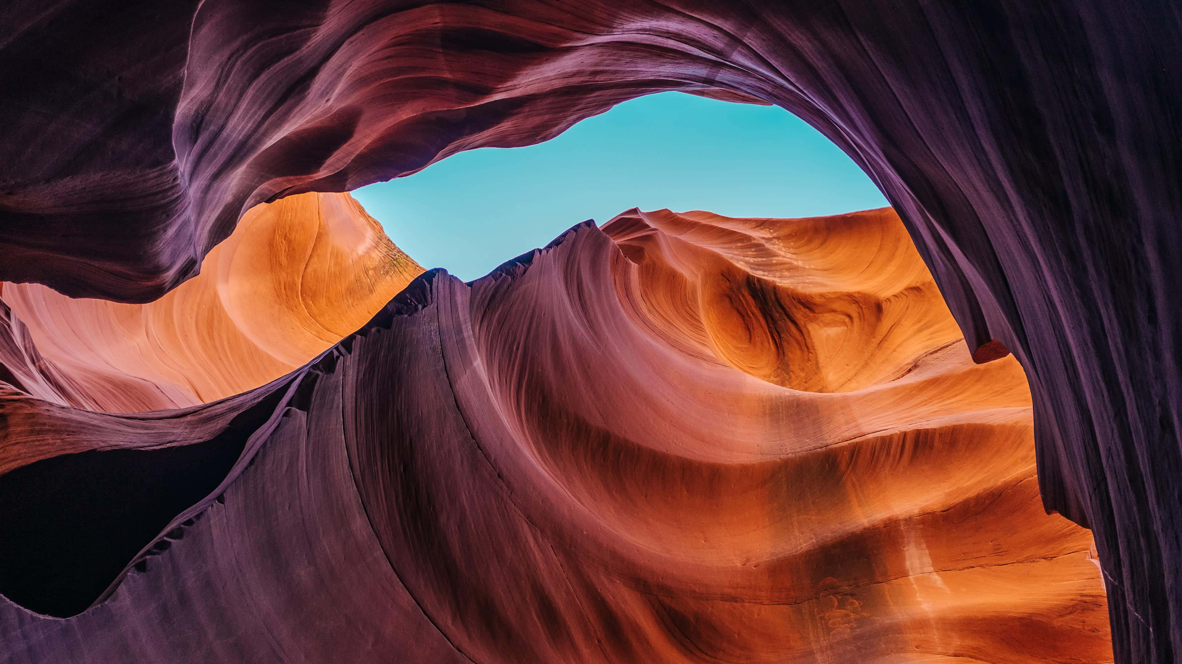 Antelope Canyon, vibrant turquoise sky, swirling orange and purple rock formations, 4K Desktop Wallpaper