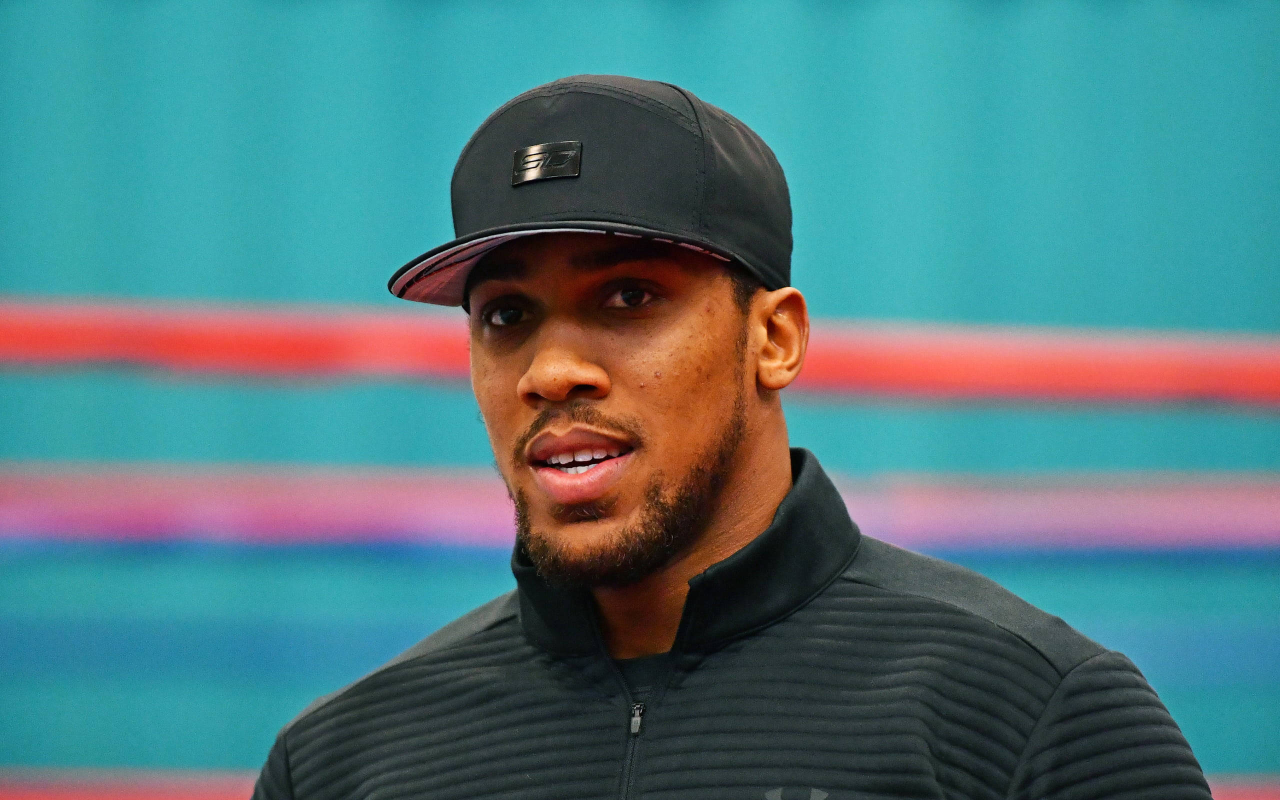 Anthony Joshua, green wall, black cap, 2K Desktop Wallpaper