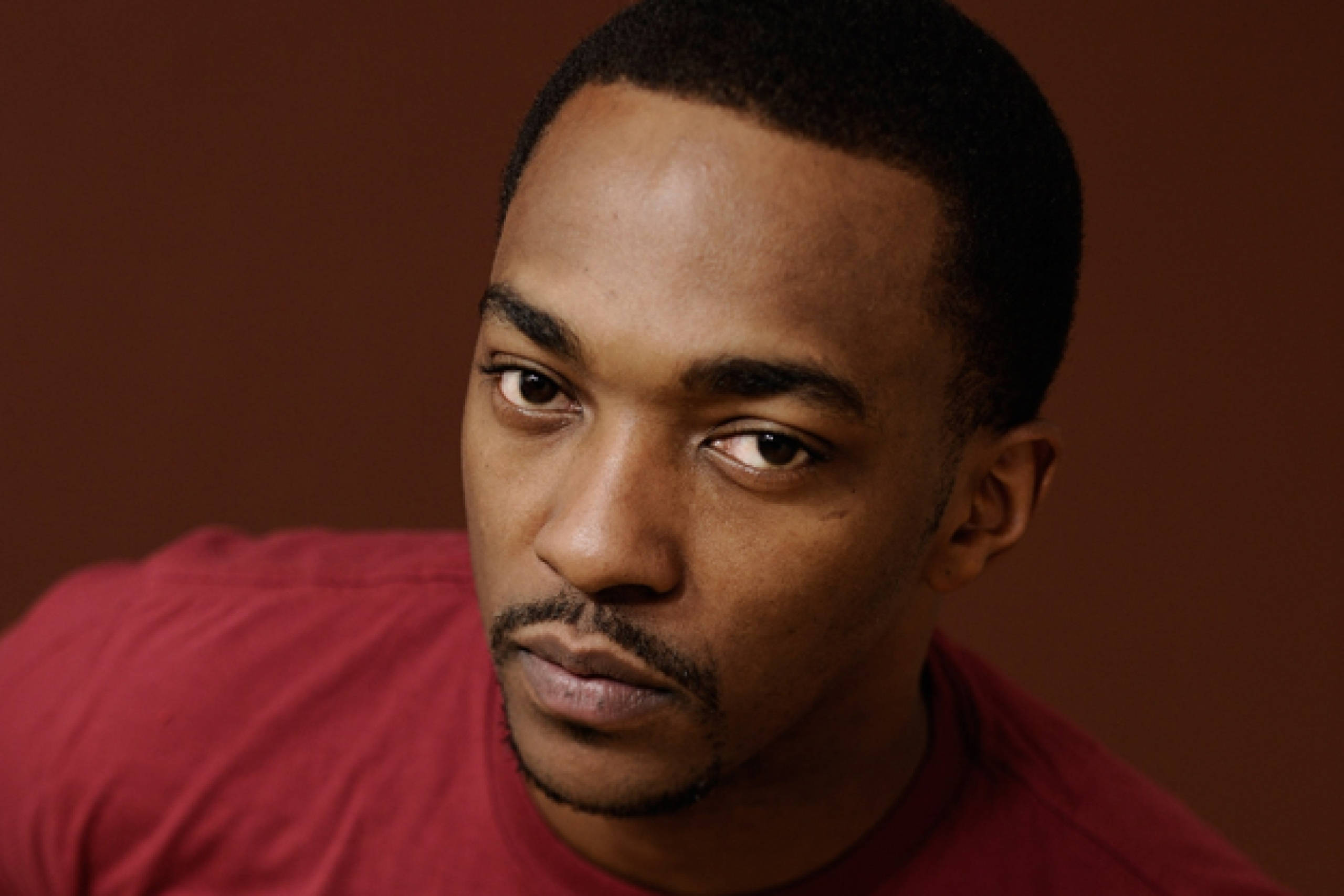 Anthony Mackie, red shirt, warm brown background, 2K Desktop Wallpaper