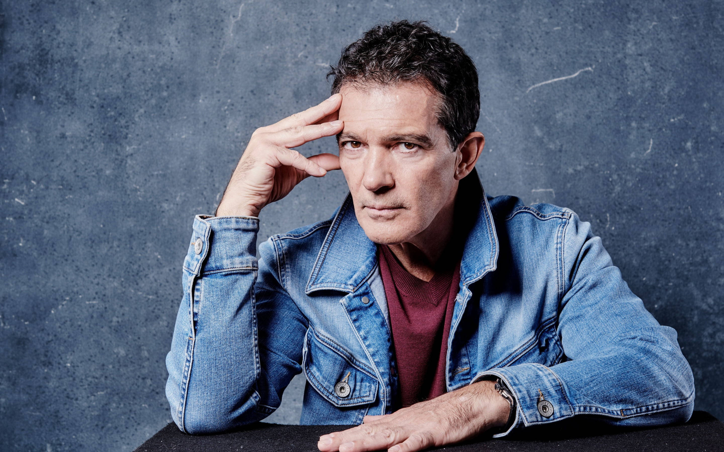 Antonio Banderas, denim jacket, textured gray wall, 2K Desktop Wallpaper