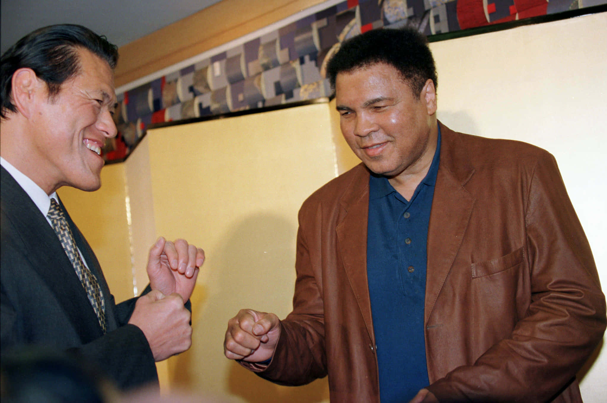 Antonio Inoki, fist bump, warmly lit indoor setting, Full HD Desktop Wallpaper