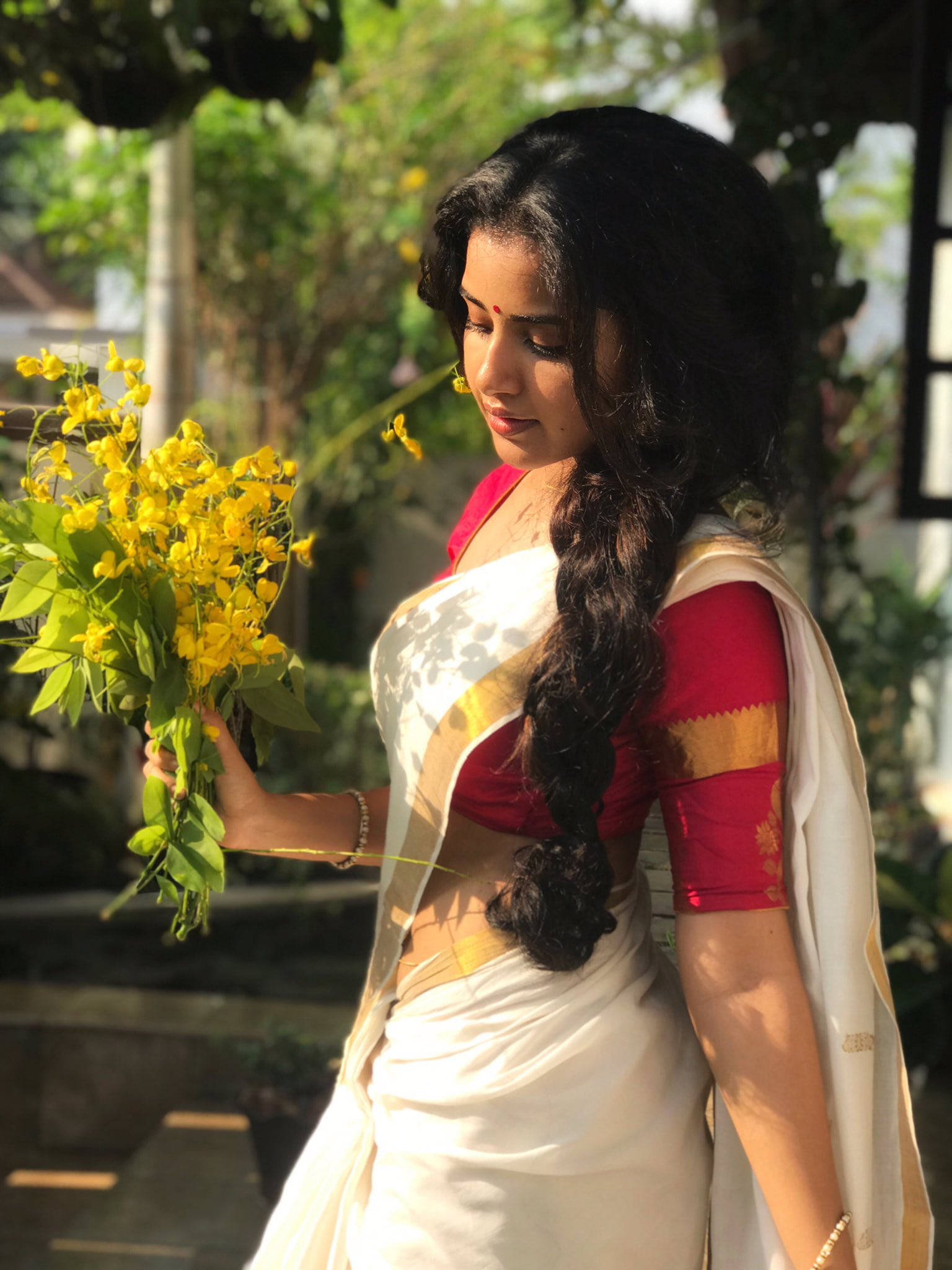 Anupama Parameswaran, yellow flower, white and red sari, Full HD Phone Wallpaper