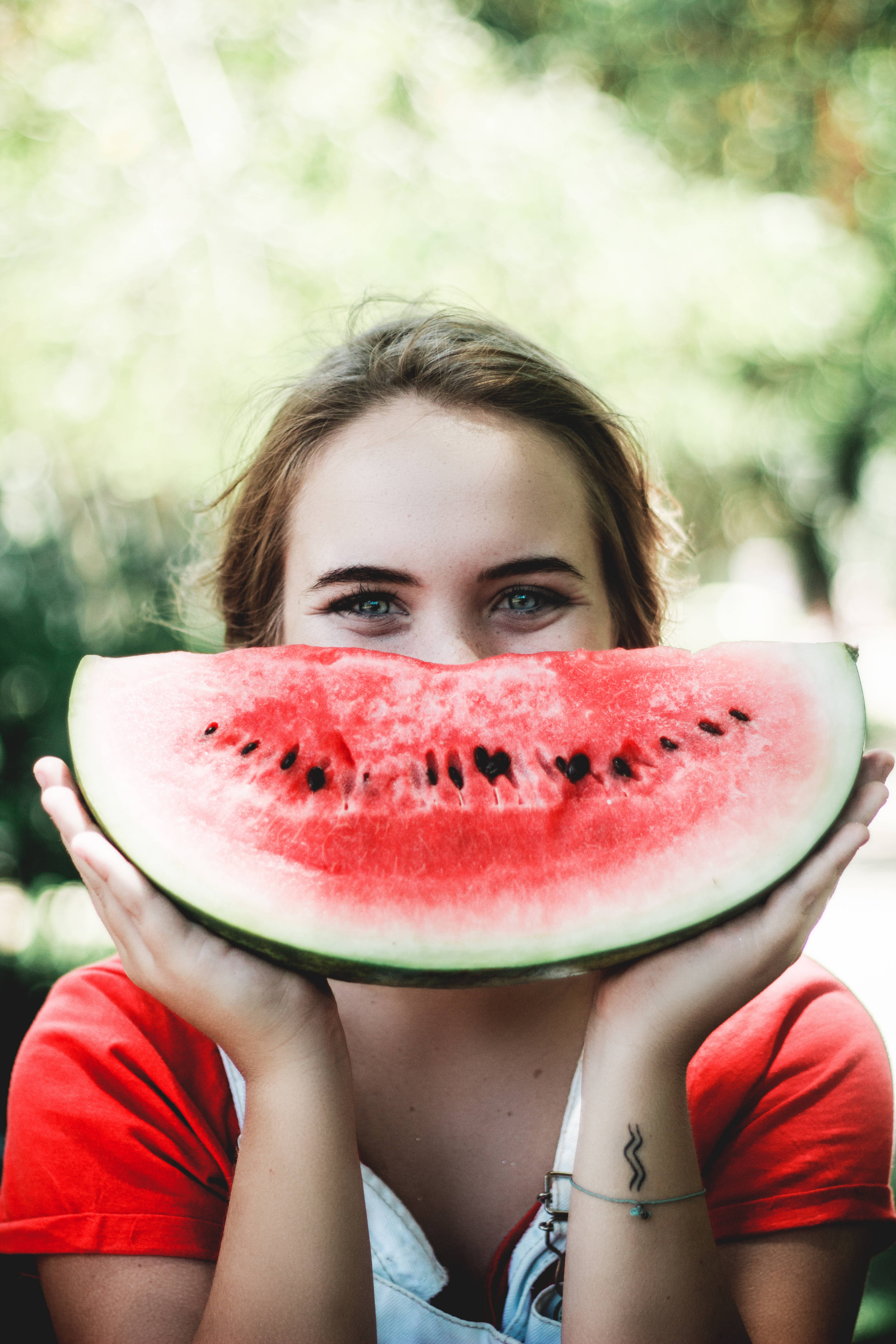 Anya Taylor-Joy, vibrant red watermelon slice, bright green eyes, 5K Phone Wallpaper