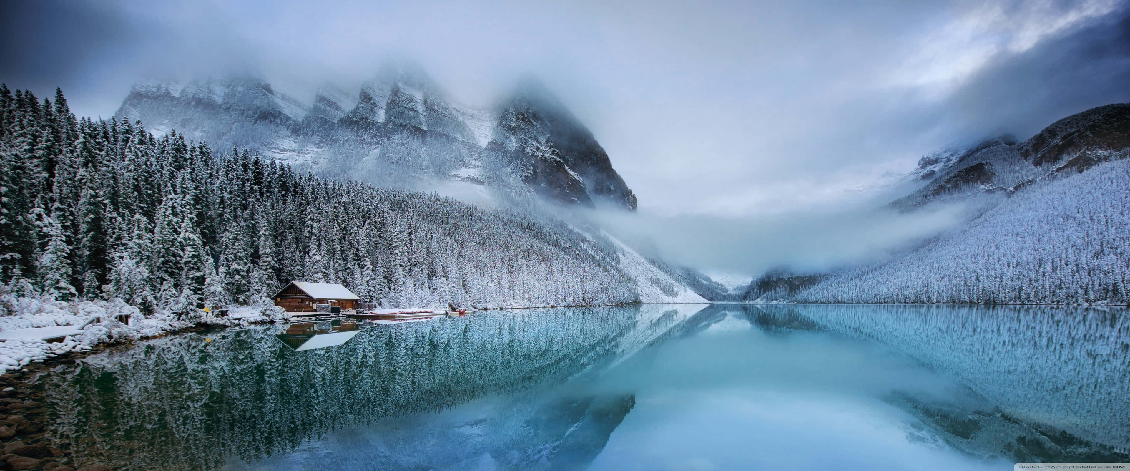 Apple 3840x1600, snow-covered wooden cabin, frozen lake, 4K Desktop Wallpaper