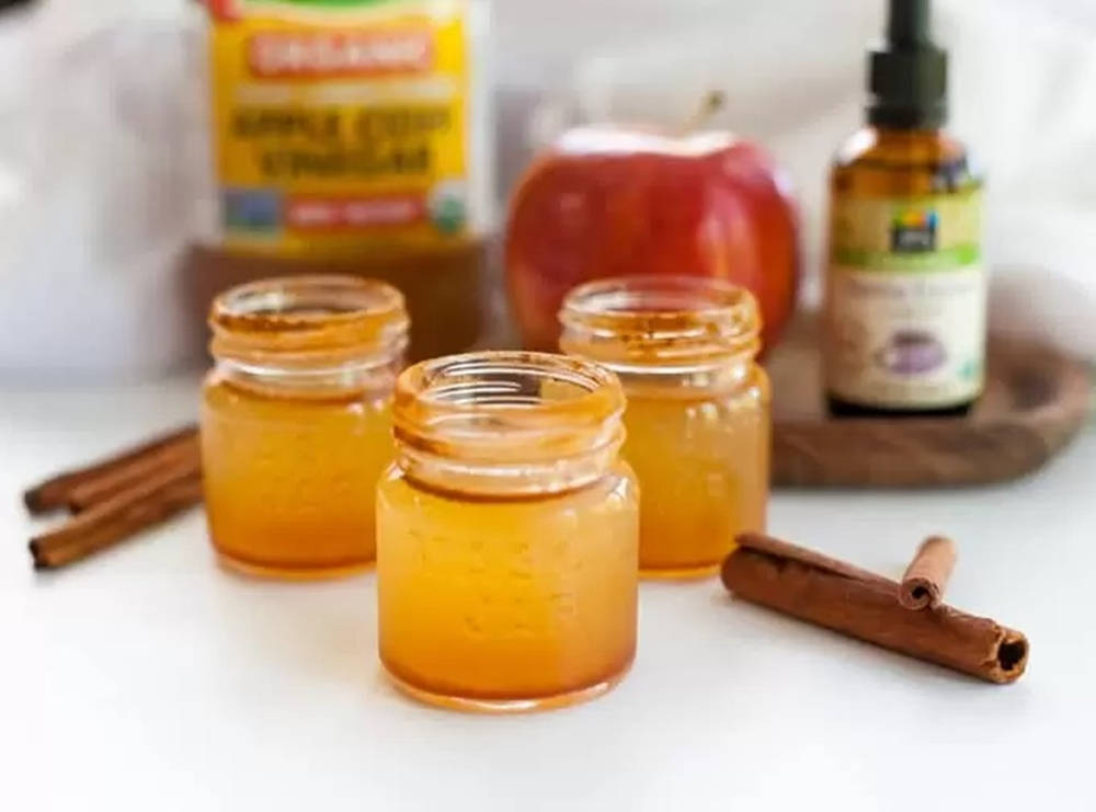 golden apple cider vinegar, white surface, cinnamon sticks, SD Desktop Wallpaper