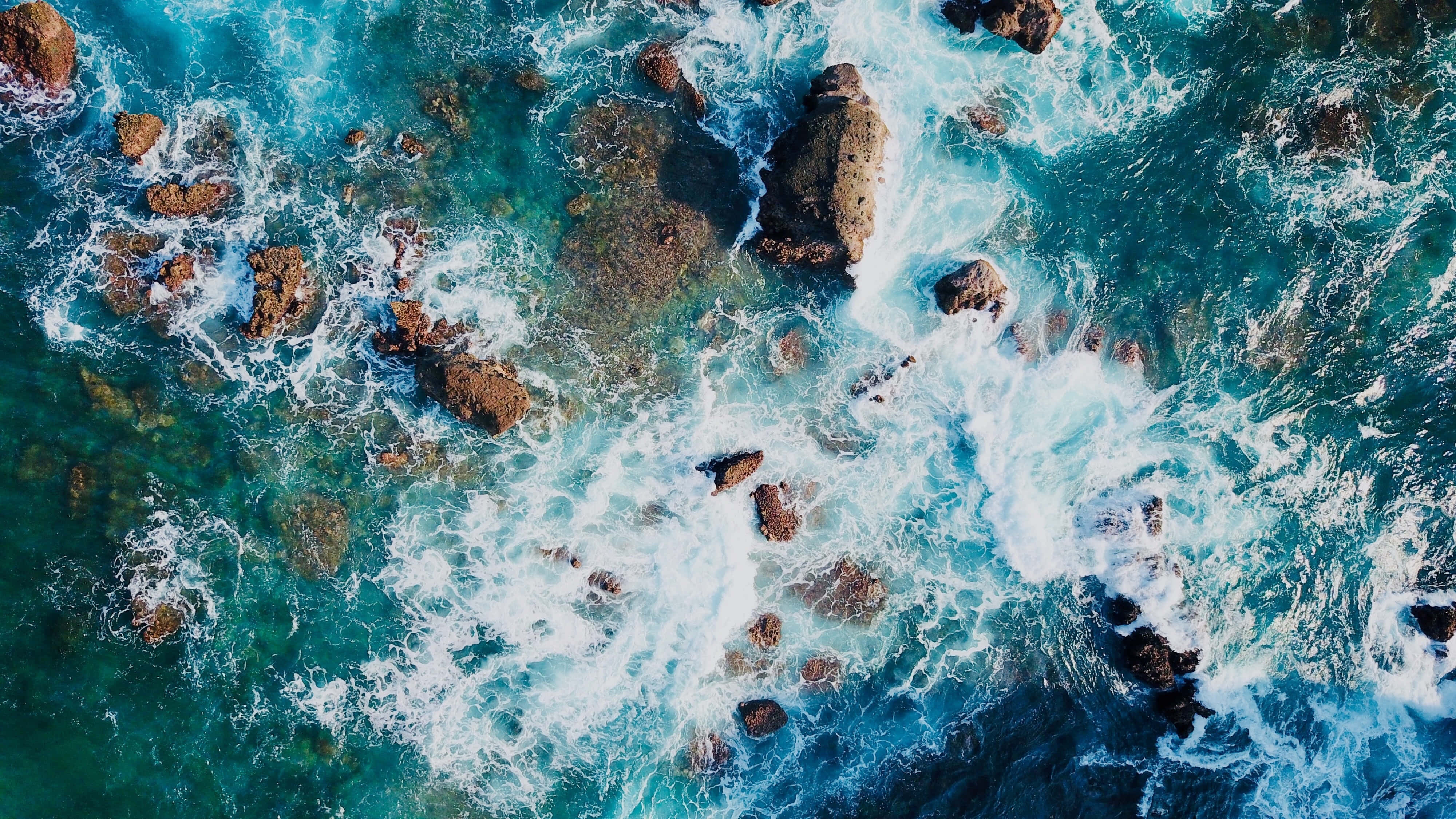 Apple Desktop, turquoise ocean, rugged brown rocks, 4K Desktop Wallpaper
