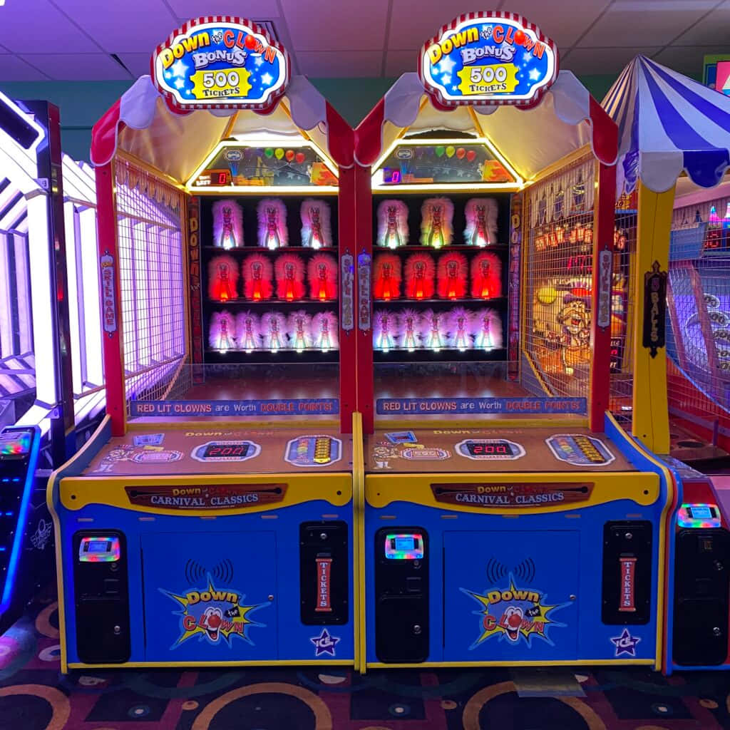 arcade gaming experience, carnival game machines, glowing red and purple clown figures, SD Desktop Wallpaper