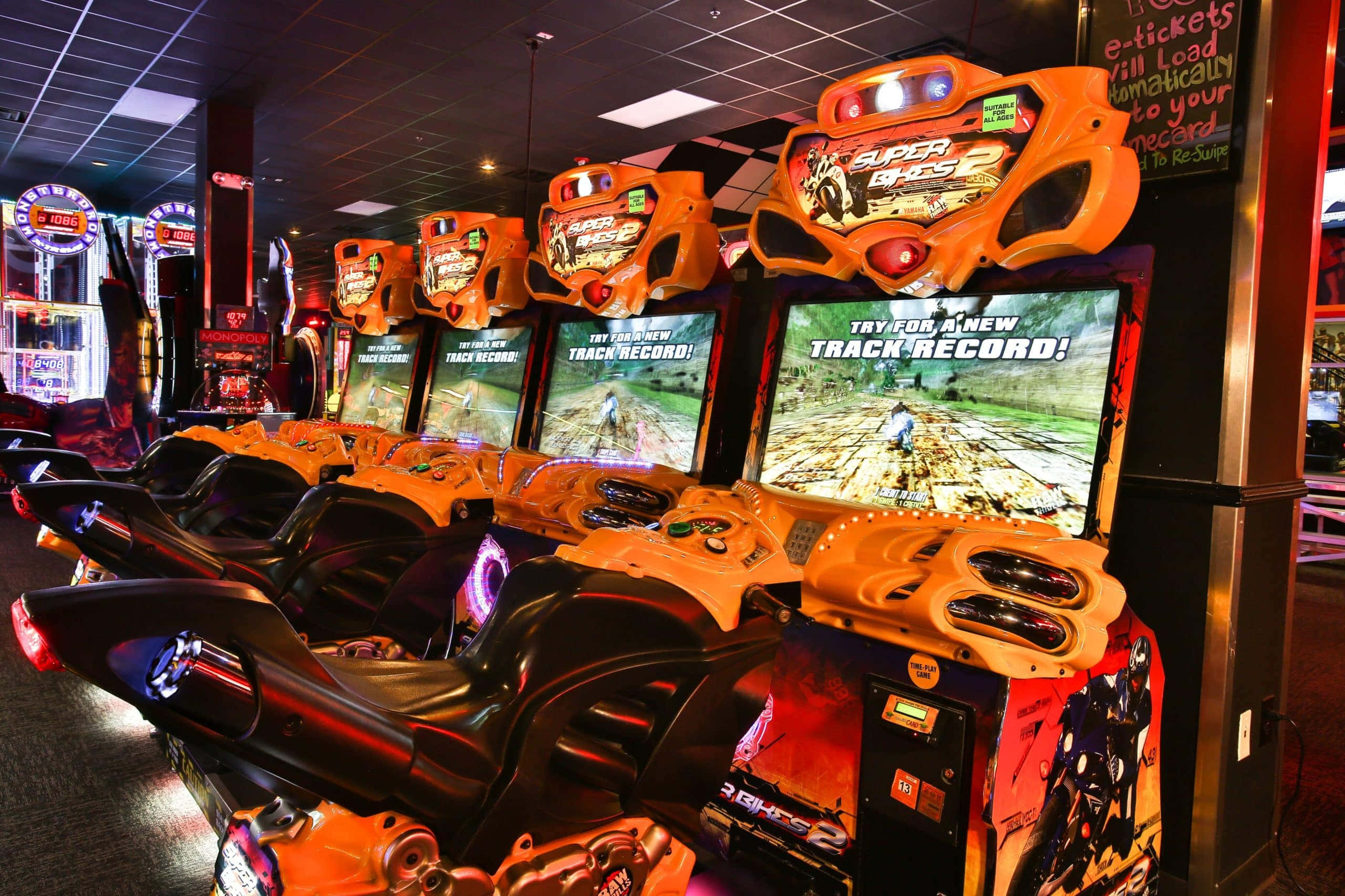 arcade games, vibrant orange racing arcade machines, glowing screens, 2K Desktop Wallpaper