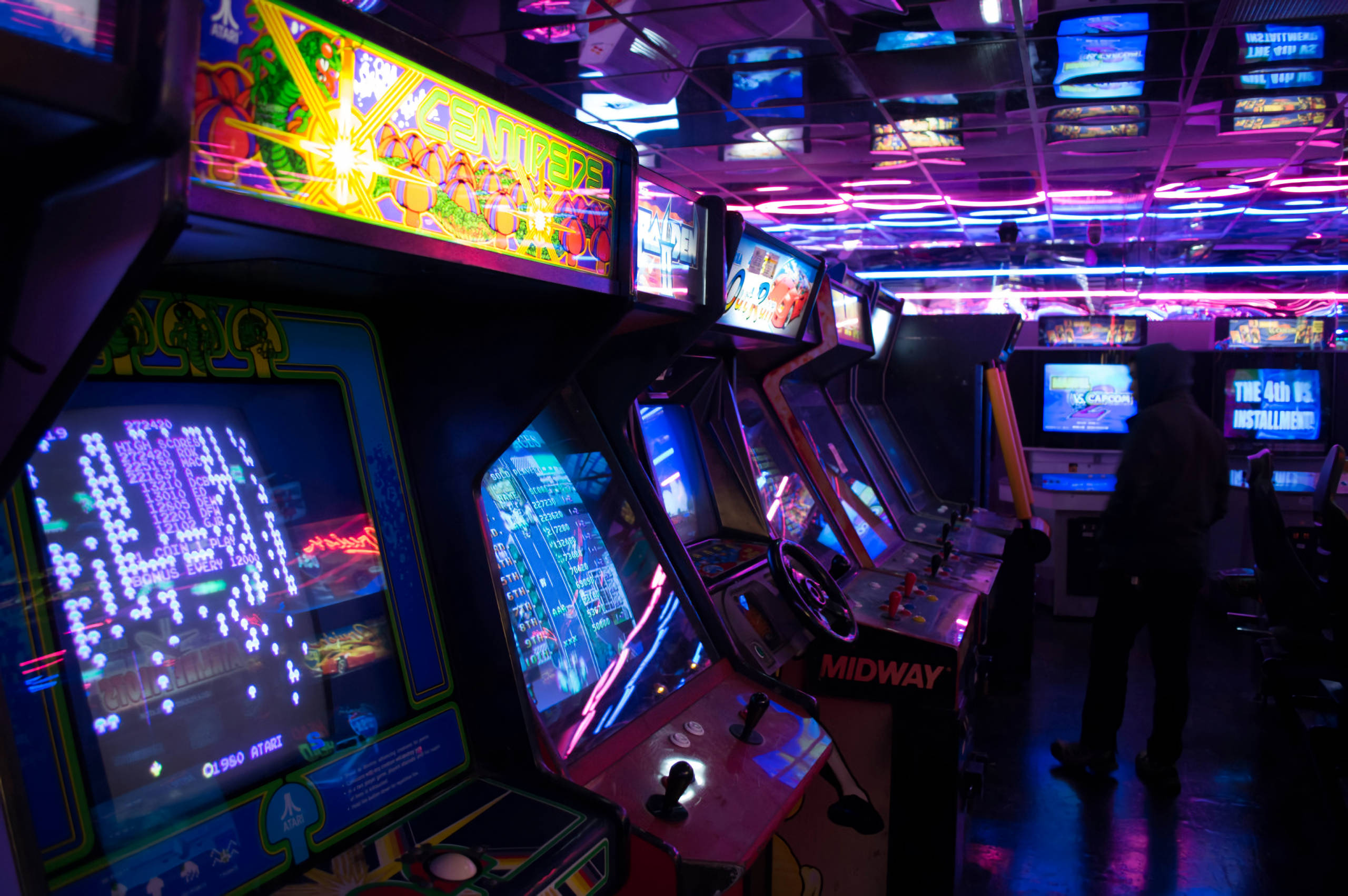 Arcade, neon-lit arcade machines, retro gaming hall, 2K Desktop Wallpaper