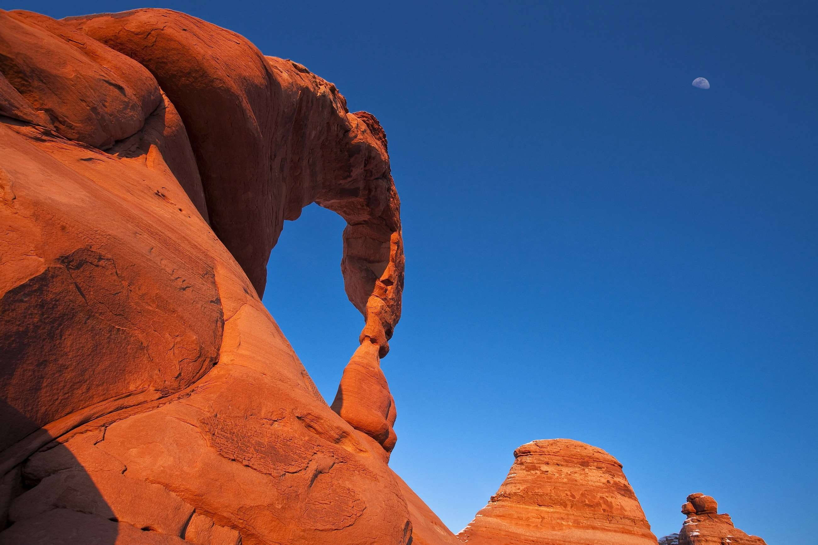 red sandstone arch, deep blue sky, crescent moon, 2K Desktop Wallpaper