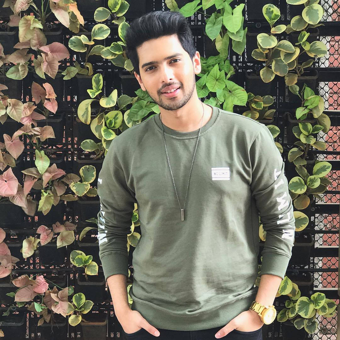Armaan Malik, olive green sweatshirt, lush green and pink leafy wall, SD Desktop Wallpaper