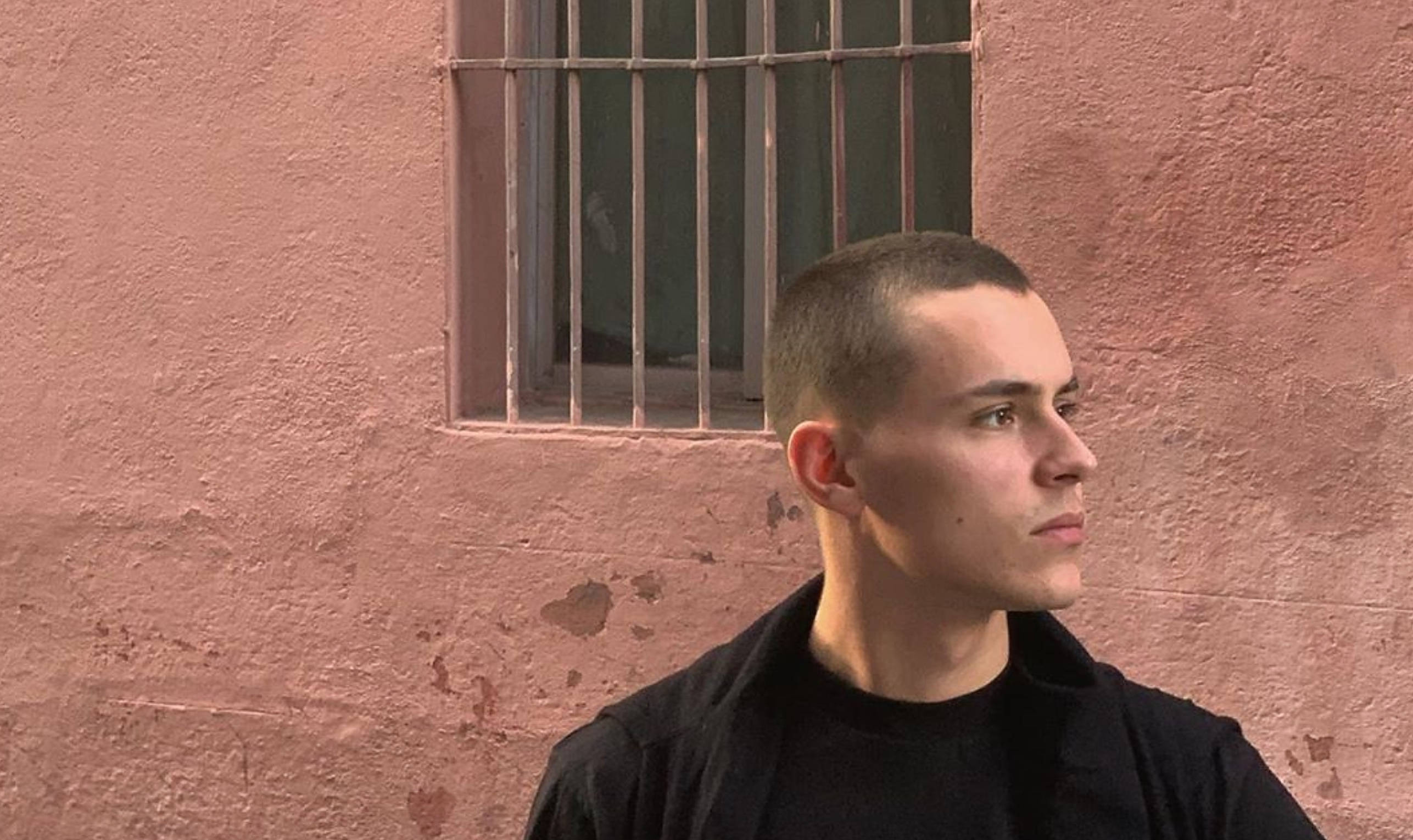 Aron Piper, black shirt, textured pink wall, 2K Desktop Wallpaper