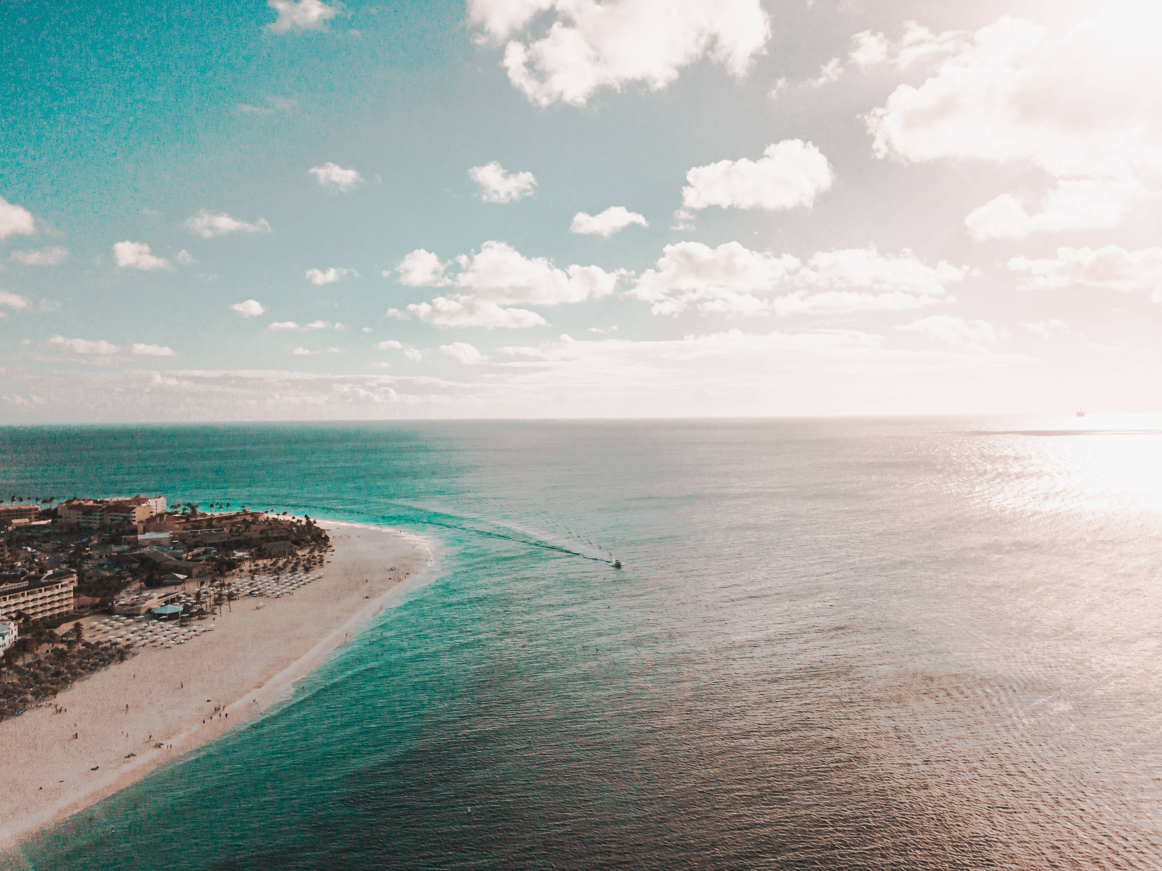 Aruba, curved turquoise beach, resort buildings, 4K Desktop Wallpaper