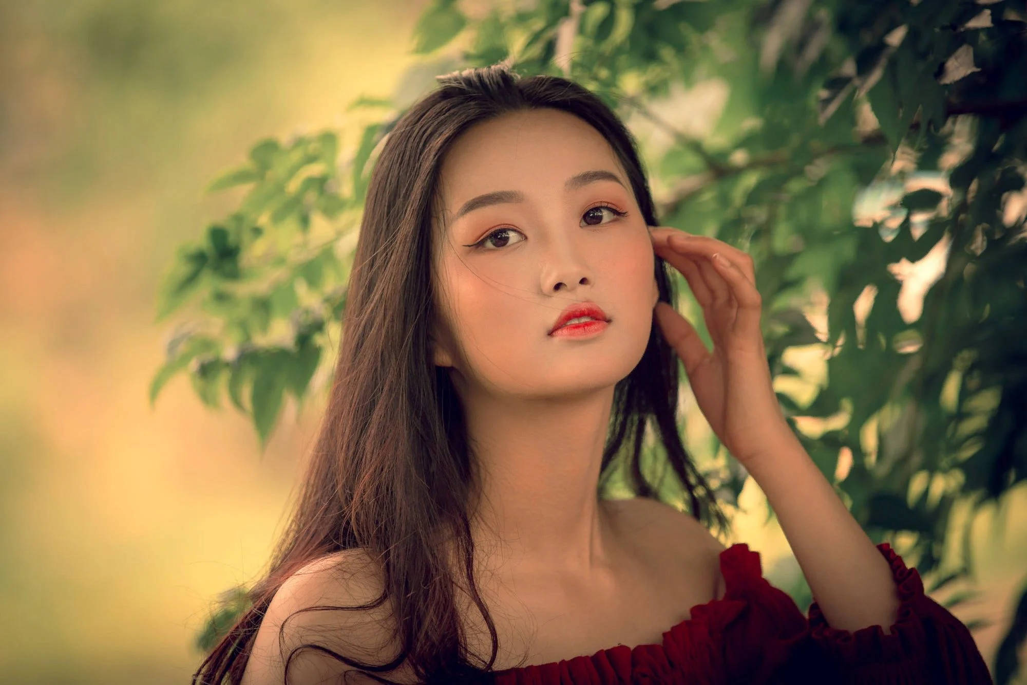 long black hair, red off-shoulder dress, soft green foliage, Full HD Desktop Wallpaper