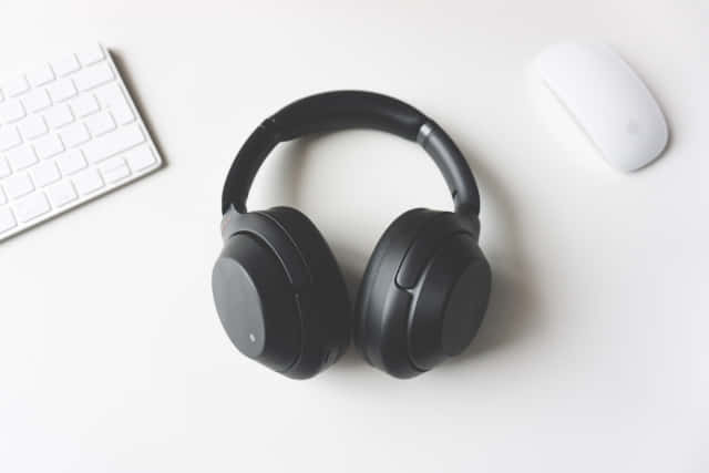 black over-ear headphones, white desk, keyboard, SD Desktop Wallpaper