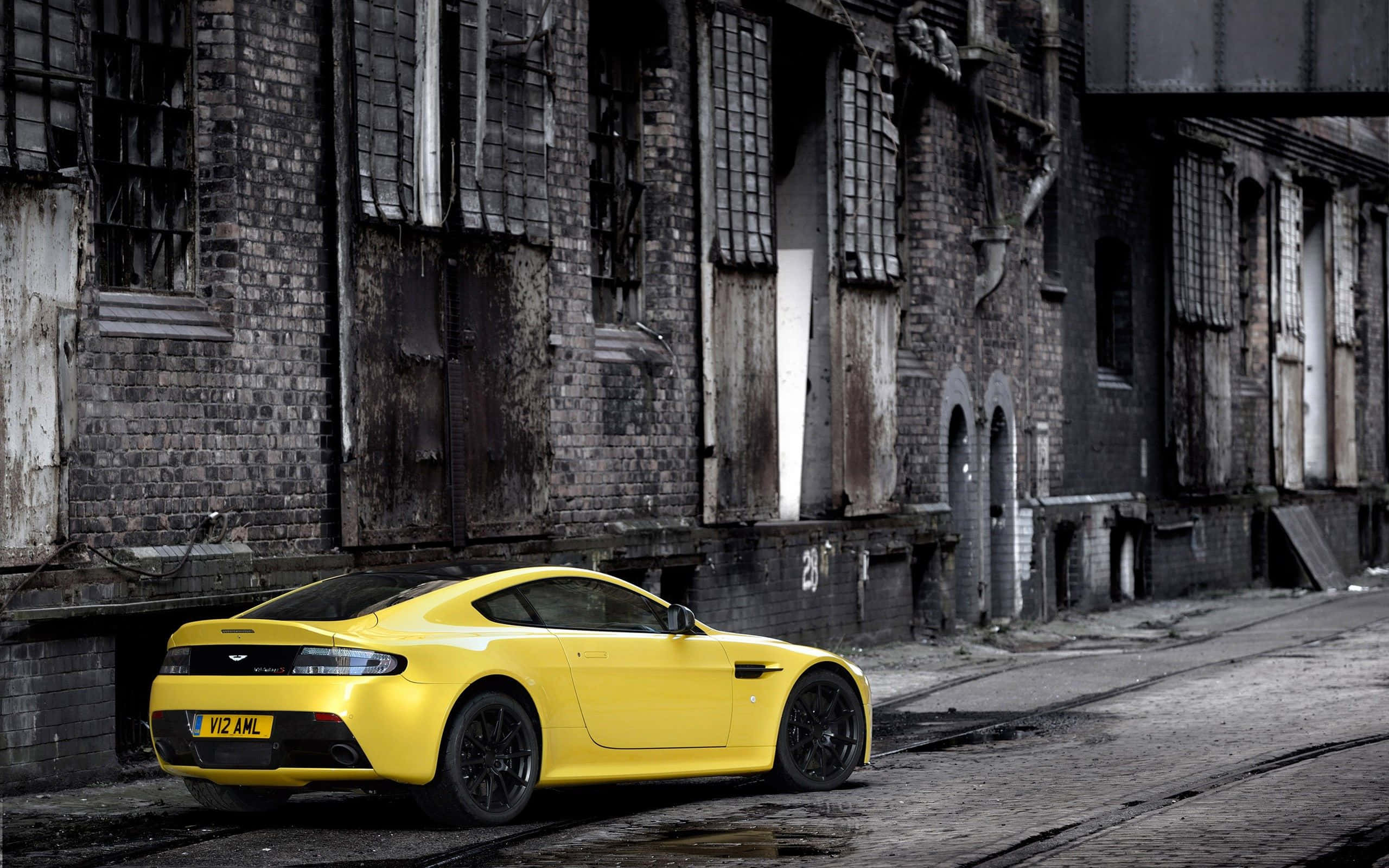 Aston Martin V12 Vantage, vibrant yellow, gritty urban street, 2K Desktop Wallpaper