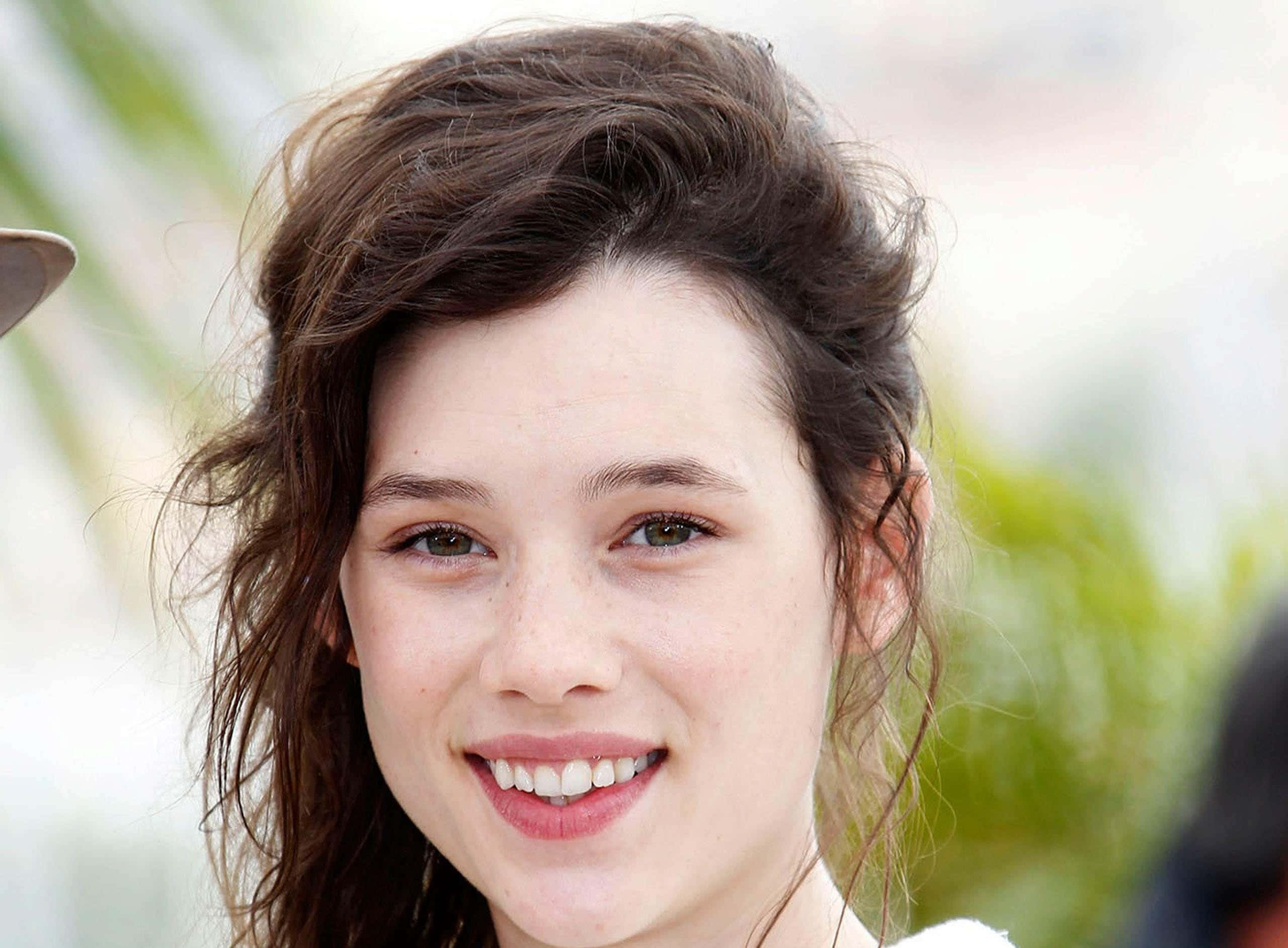 Astrid Berges-Frisbey, tousled brown hair, warmly smiling, 2K Desktop Wallpaper