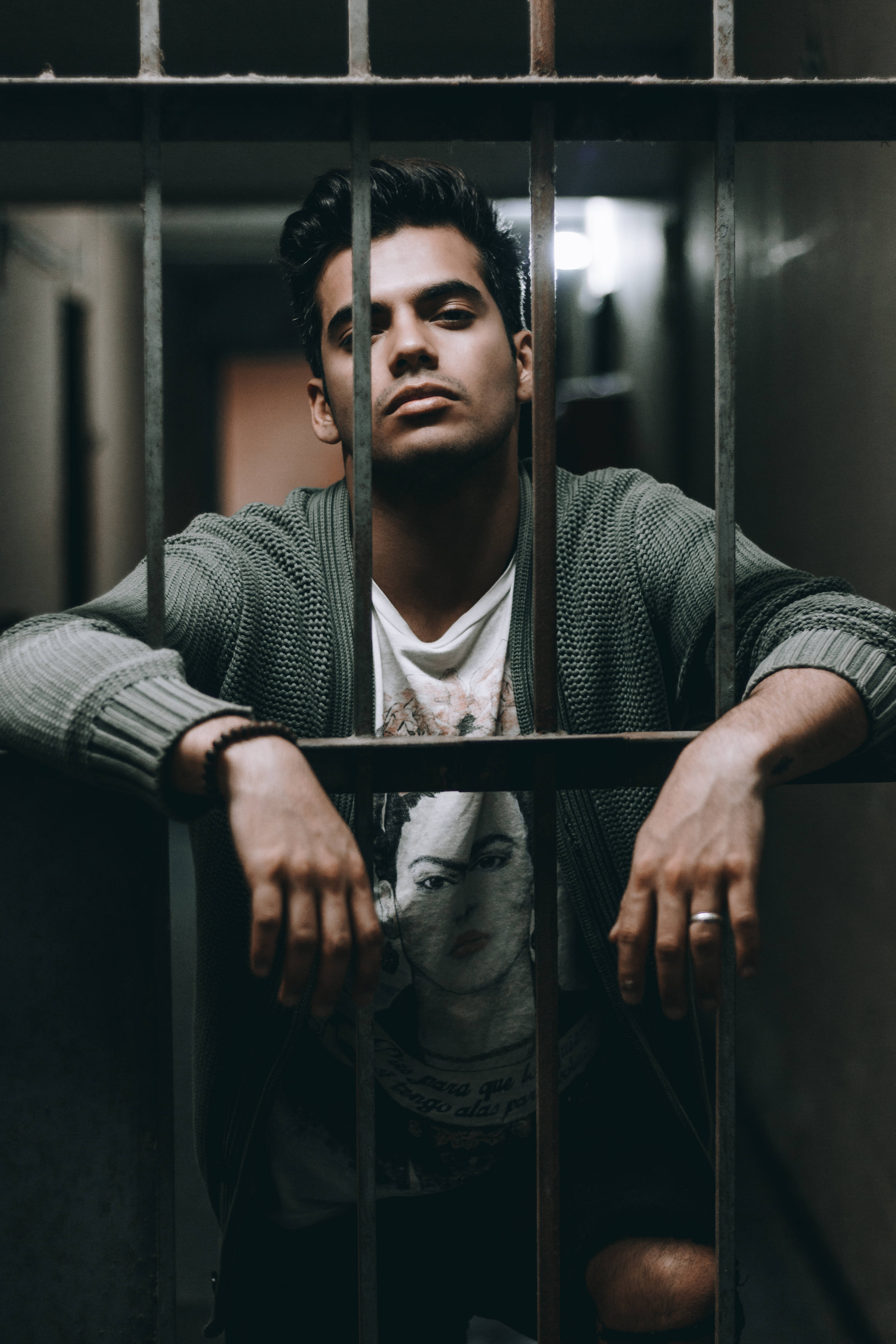 Attitude Boy, metal bars, dimly lit prison cell, 4K Phone Wallpaper