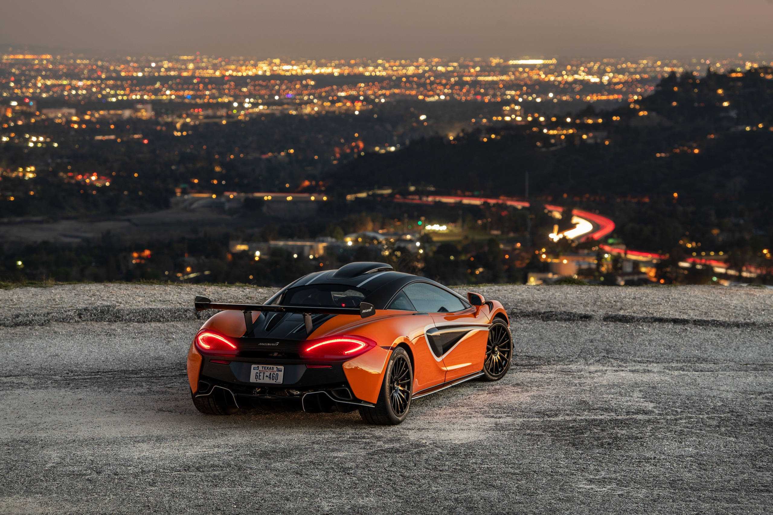 vibrant orange sports car, glowing taillights, hill, 2K Desktop Wallpaper