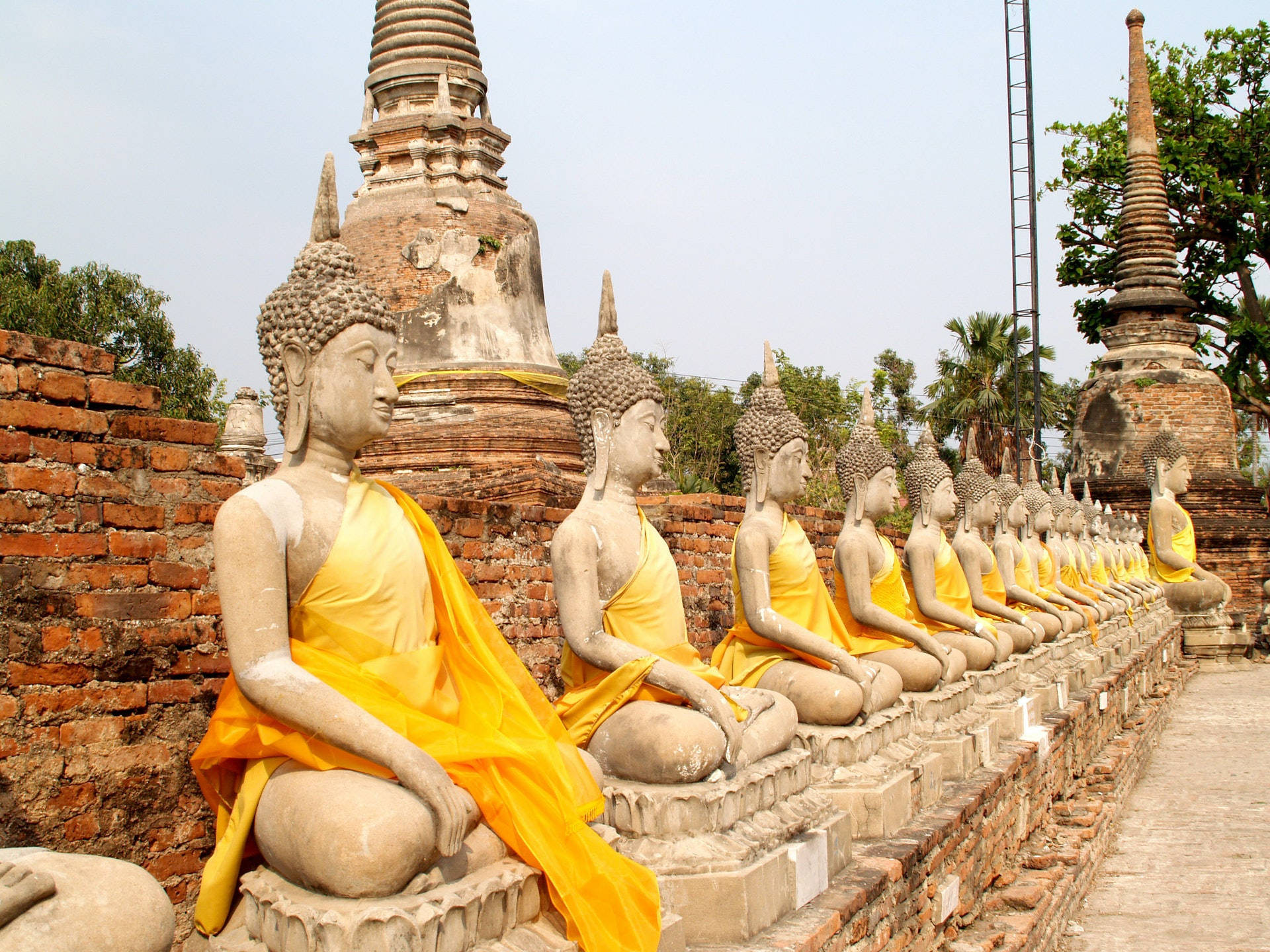 Ayutthaya Historical Park, stone Buddha statues, vibrant yellow cloths, Full HD Desktop Wallpaper