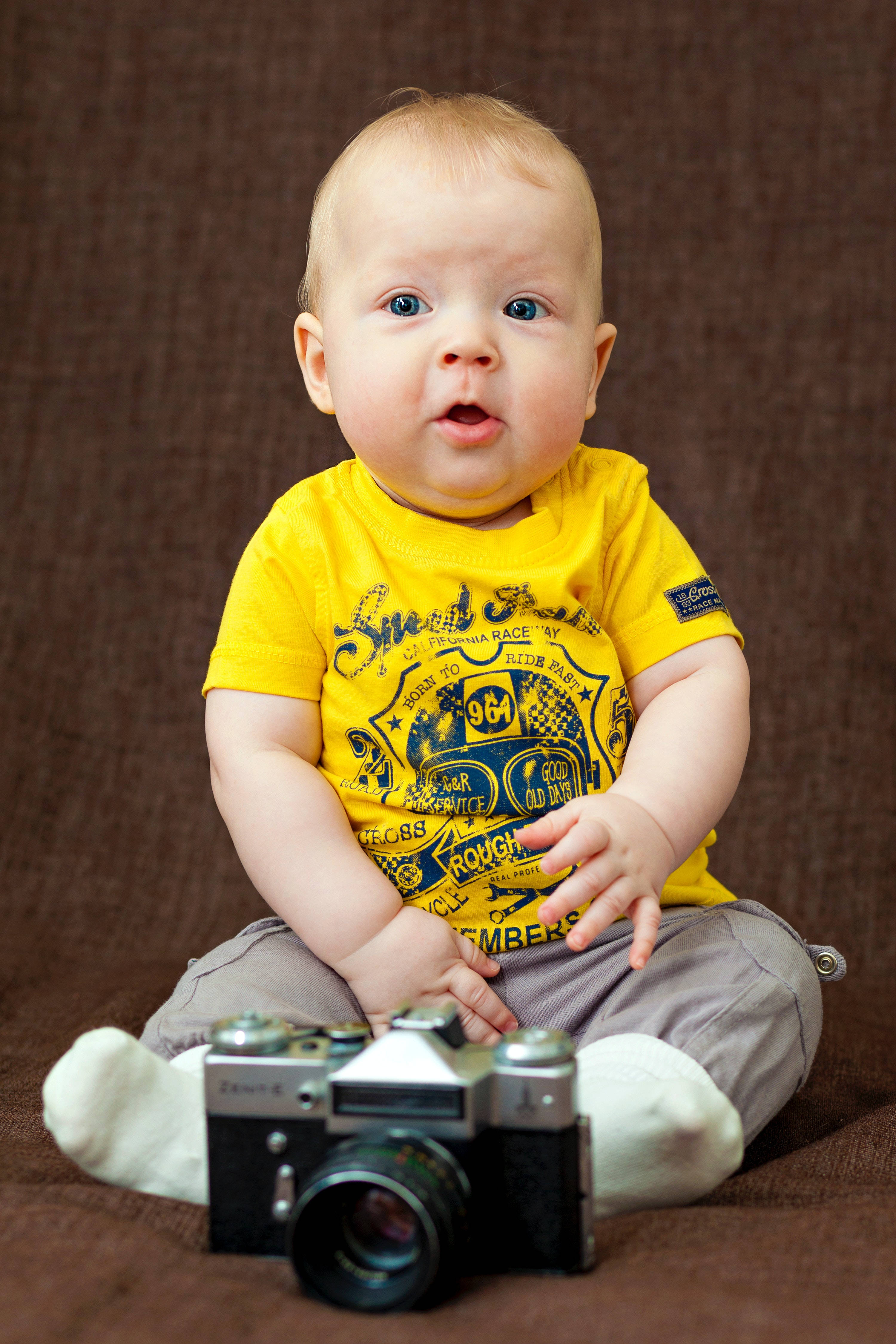 baby boy, yellow shirt, brown textured surface, 4K Phone Wallpaper