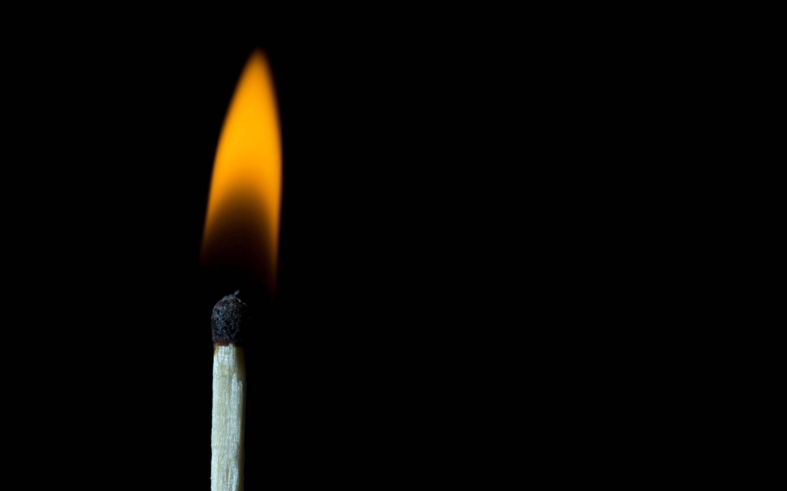 burning match, warm orange flame, stark black background, 2K Desktop Wallpaper