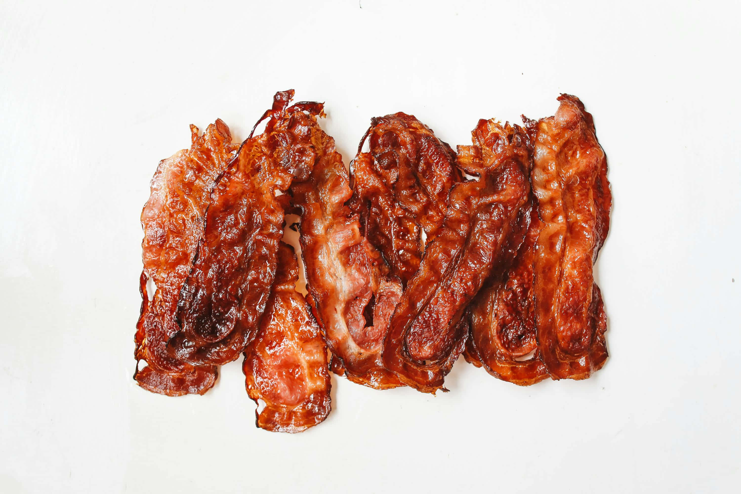 crispy cooked bacon strips, golden-brown, glistening fat, 2K Desktop Wallpaper