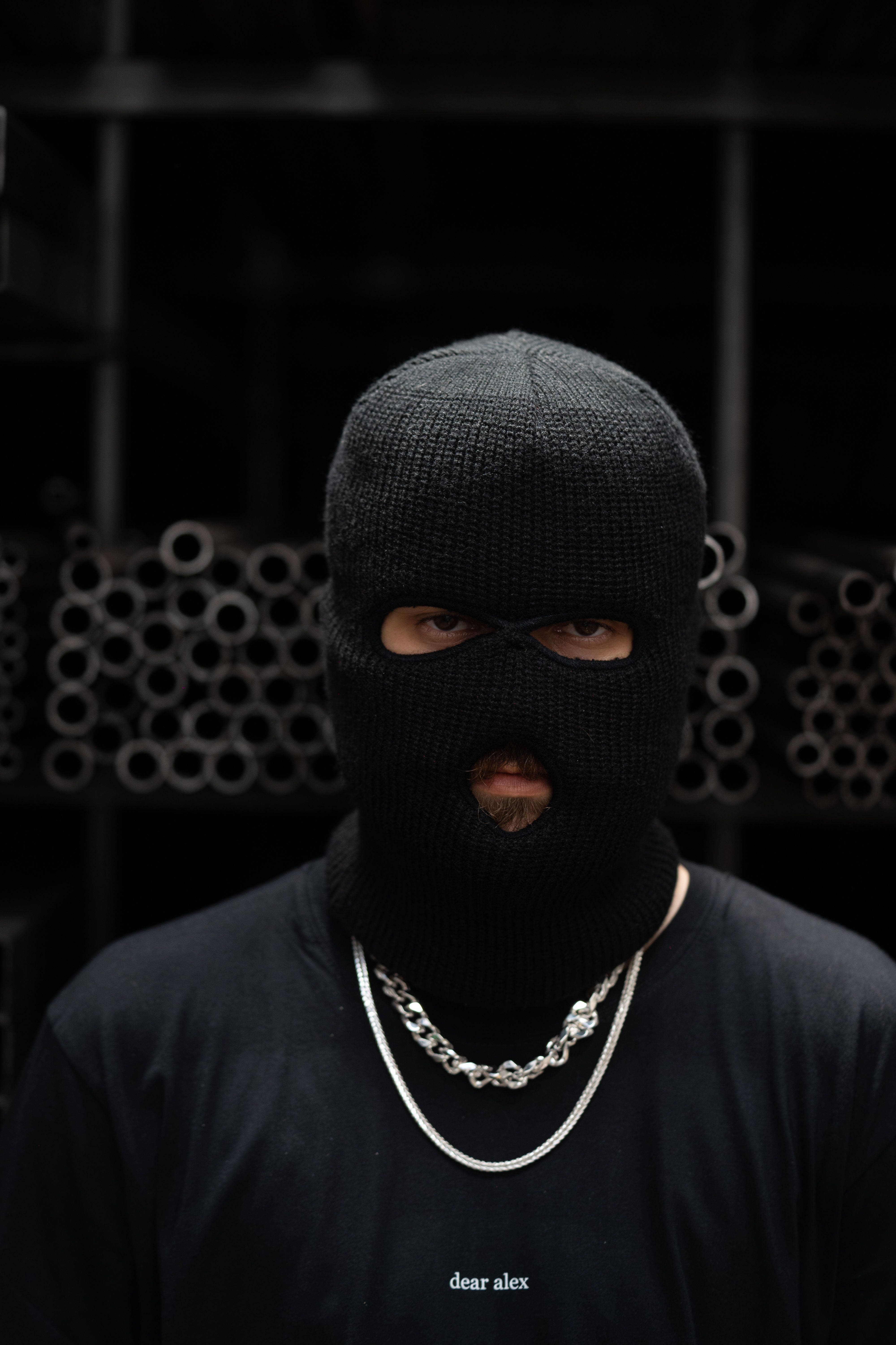 black knit balaclava, silver chain necklace, dark industrial pipe background, 5K Phone Wallpaper