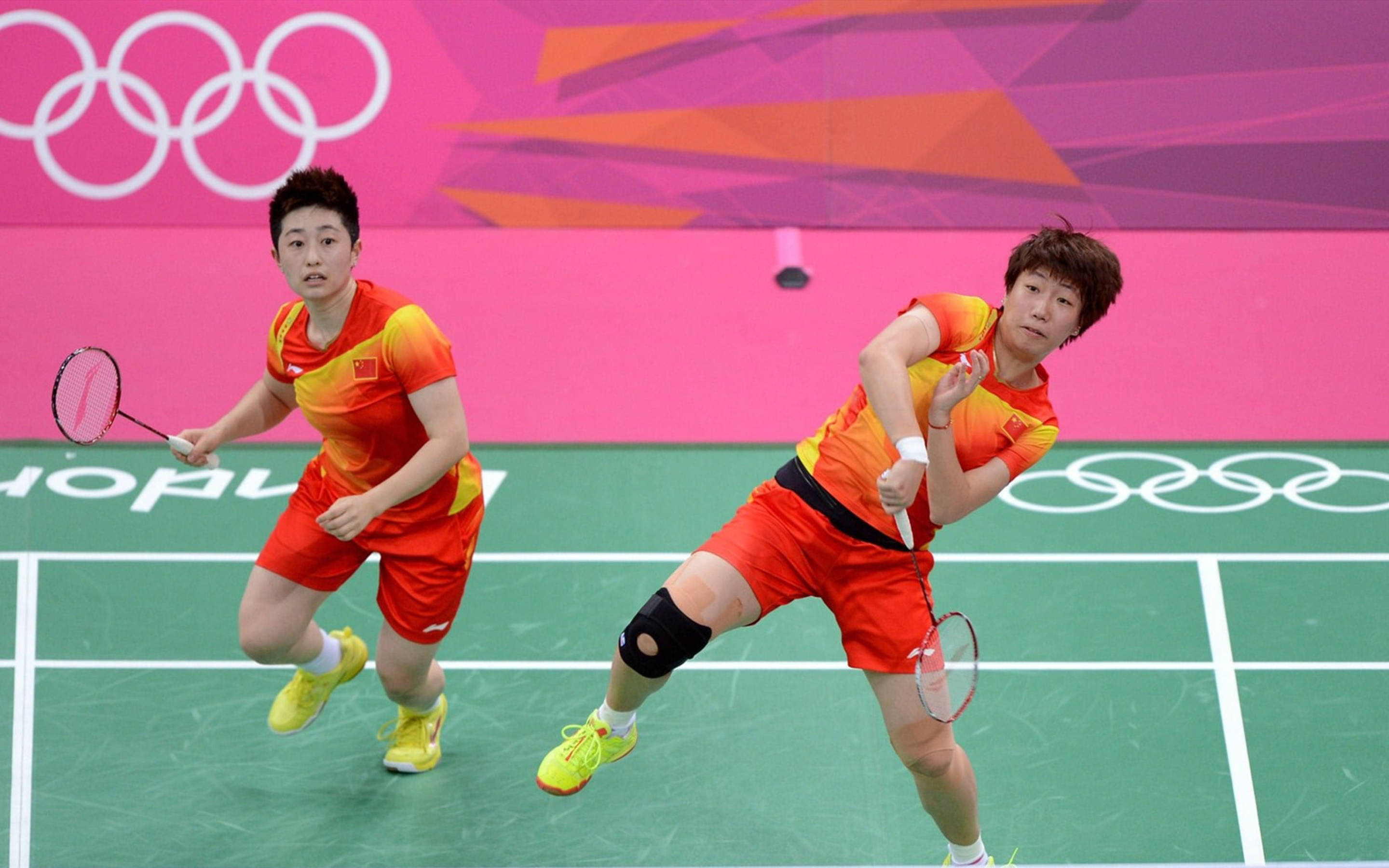 badminton players of china, red and yellow uniforms, green court, 2K Desktop Wallpaper