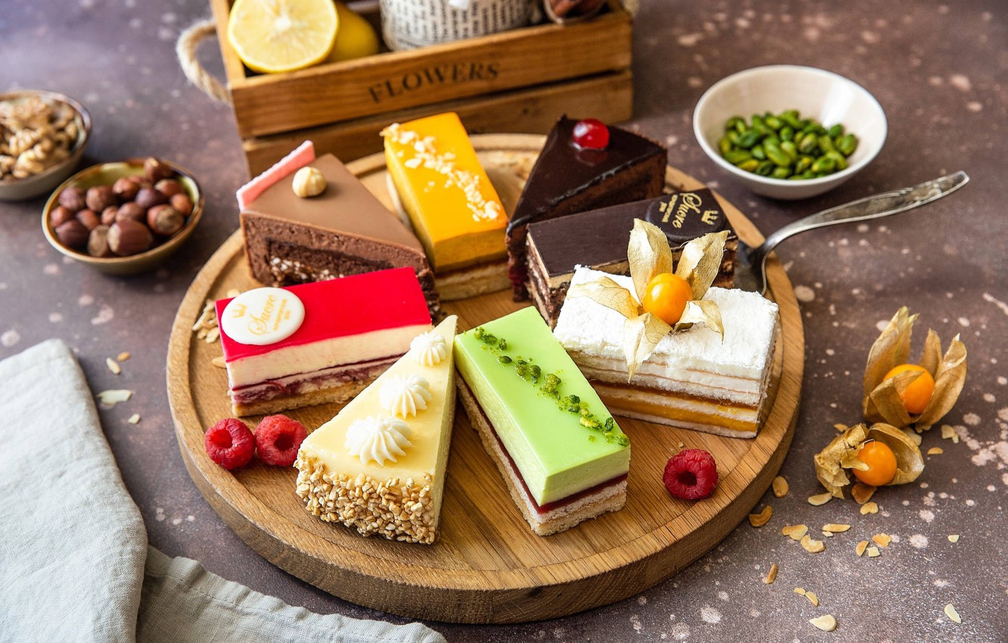 wooden platter, seven vibrant gourmet dessert slices, fresh berries, Full HD Desktop Wallpaper
