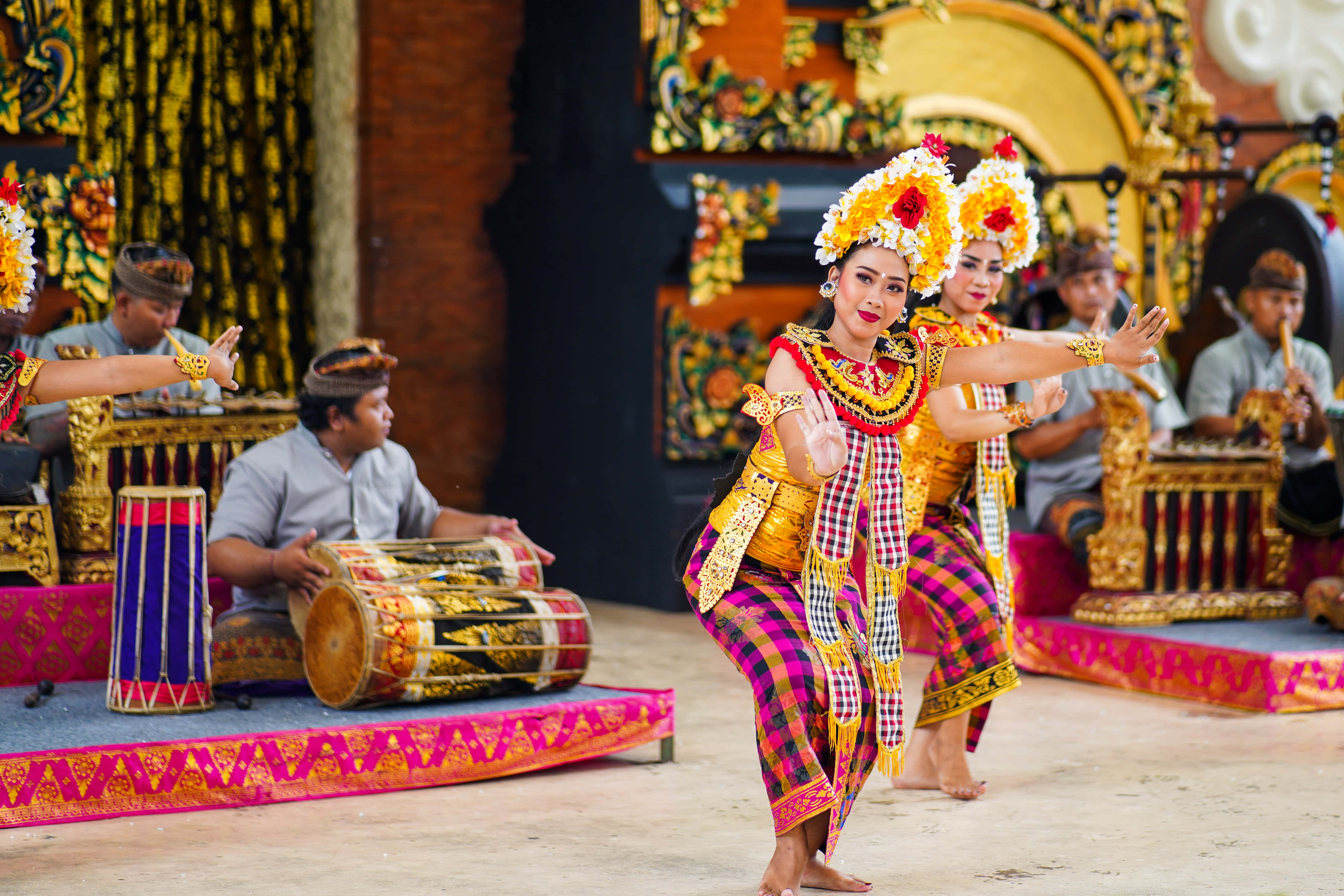 Balinese traditional dance, vibrant yellow pink and gold costumes, decorated stage, 4K Desktop Wallpaper