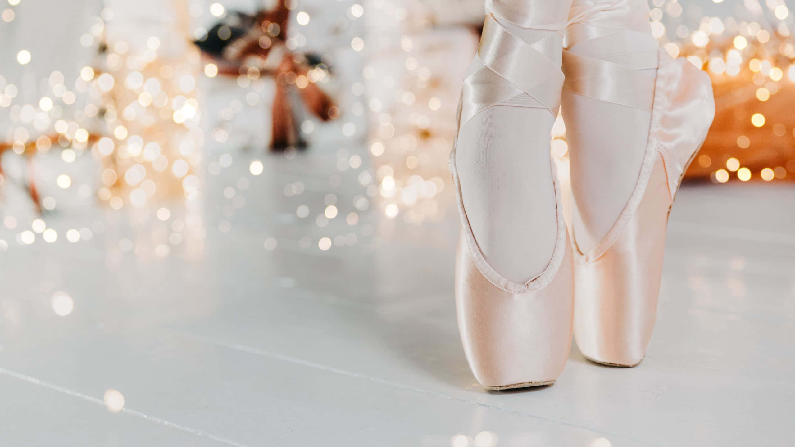 pink satin ballet pointe shoes, white floor, warm bokeh lights, 2K Desktop Wallpaper