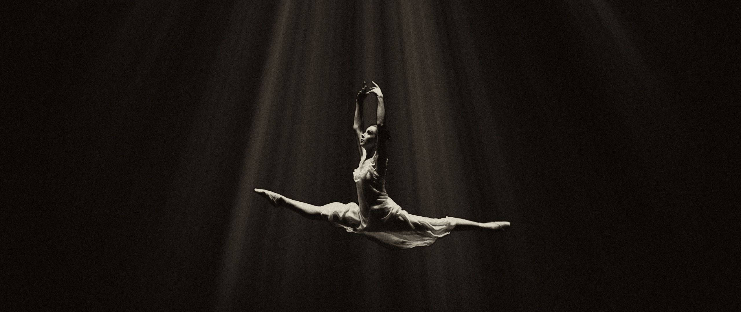 ballet dancer, graceful split, dramatic spotlight beams, 2K Desktop Wallpaper