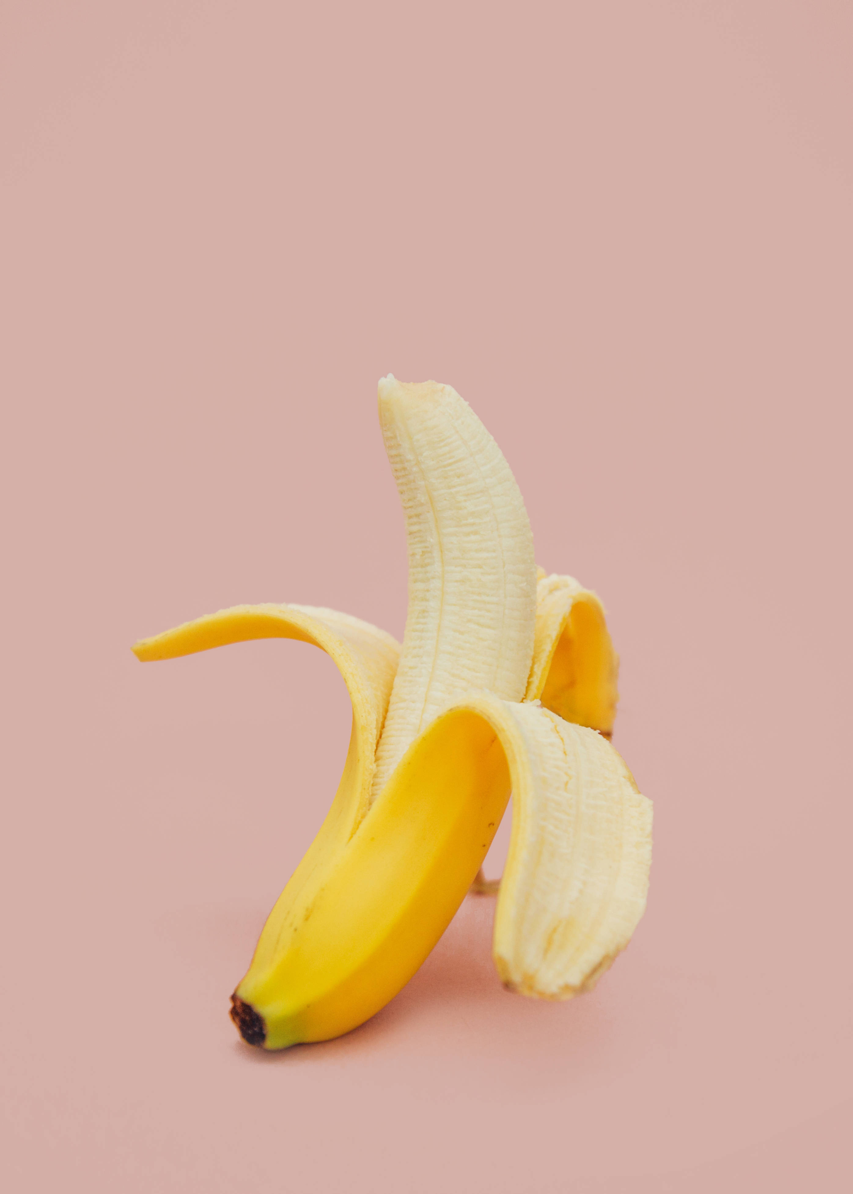 peeled banana, vibrant yellow peel, soft pink background, 4K Phone Wallpaper