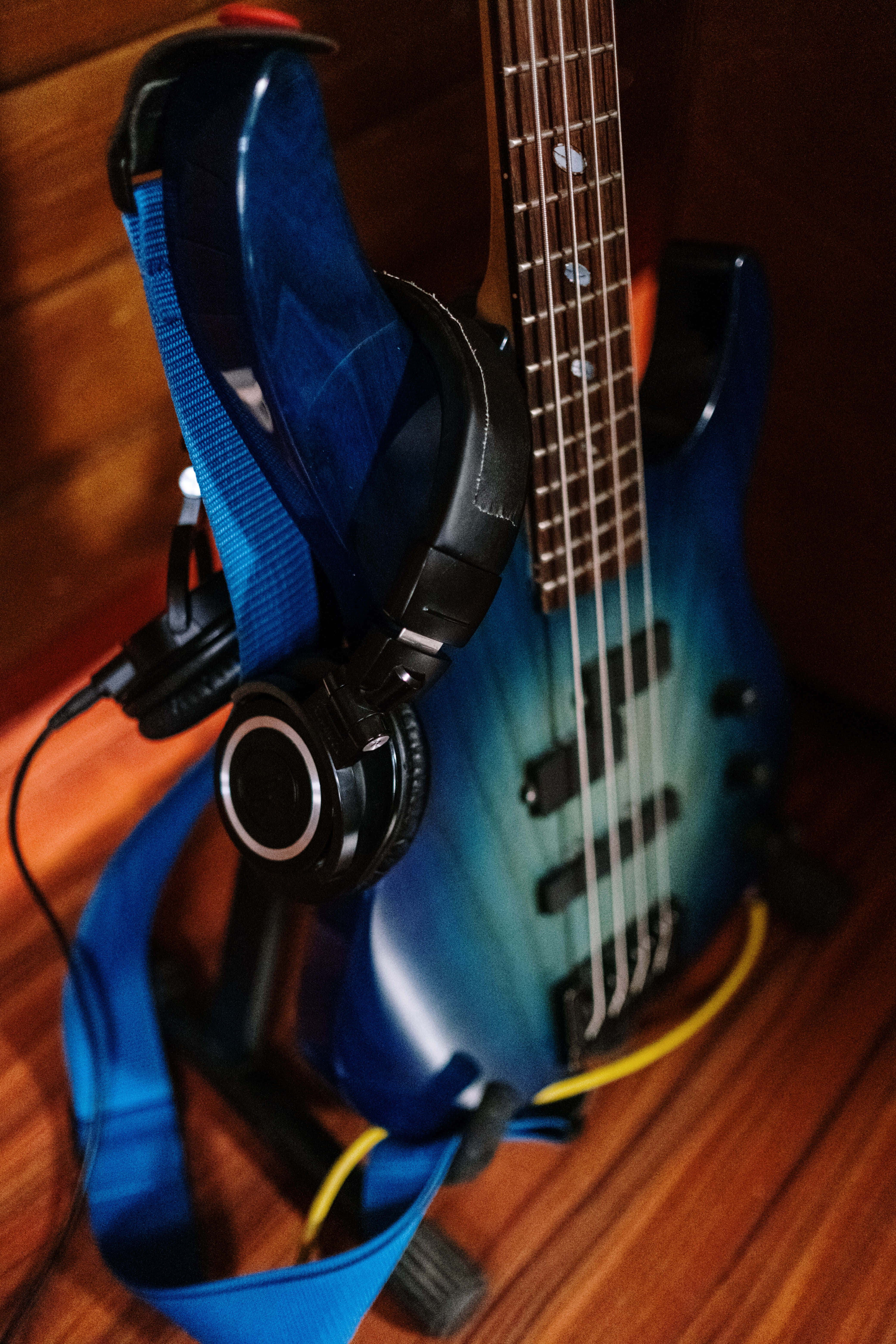 blue gradient bass guitar, black headphones, wooden floor, 5K Phone Wallpaper