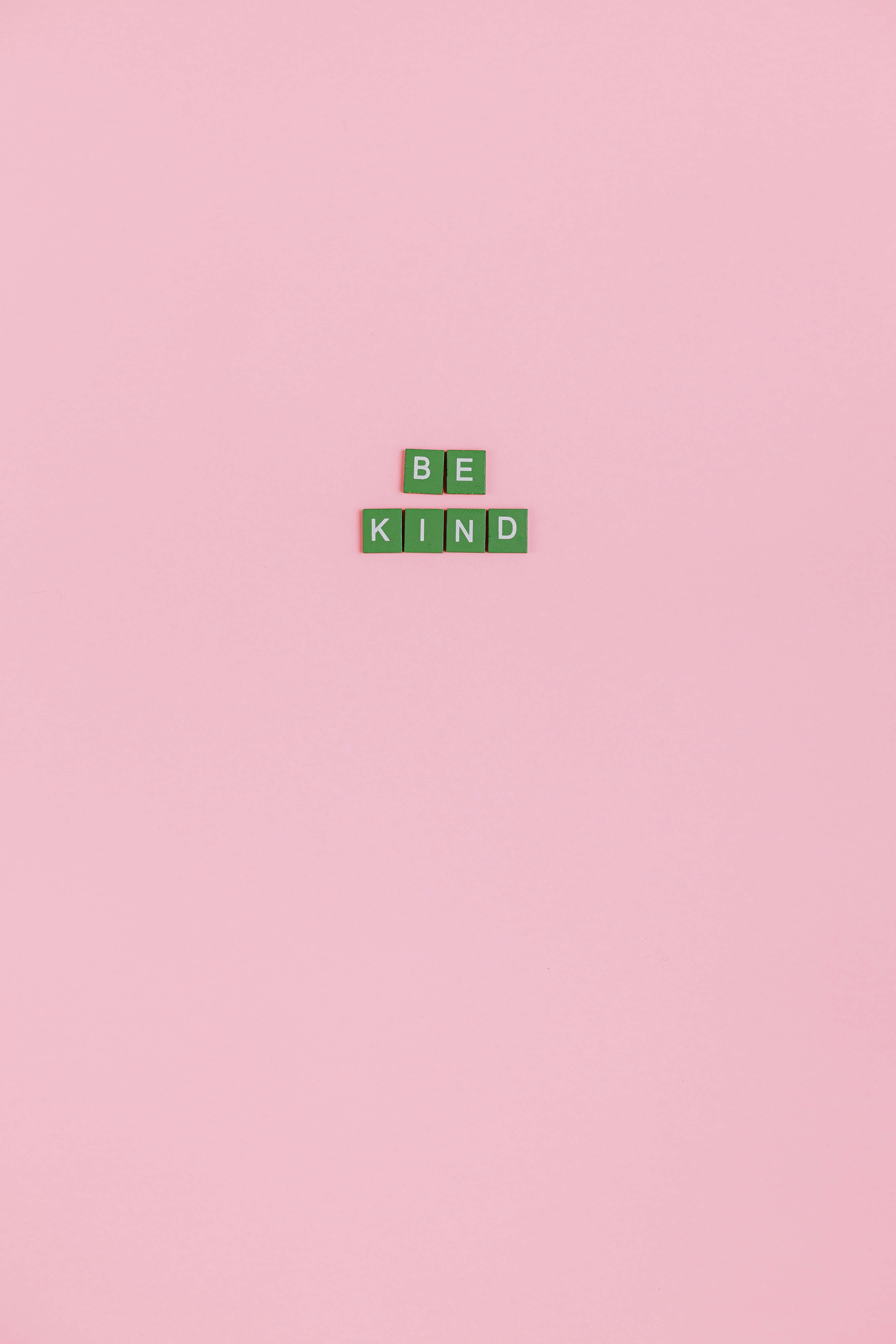 BE KIND, green letter tiles, soft pink minimalist background, 5K Phone Wallpaper