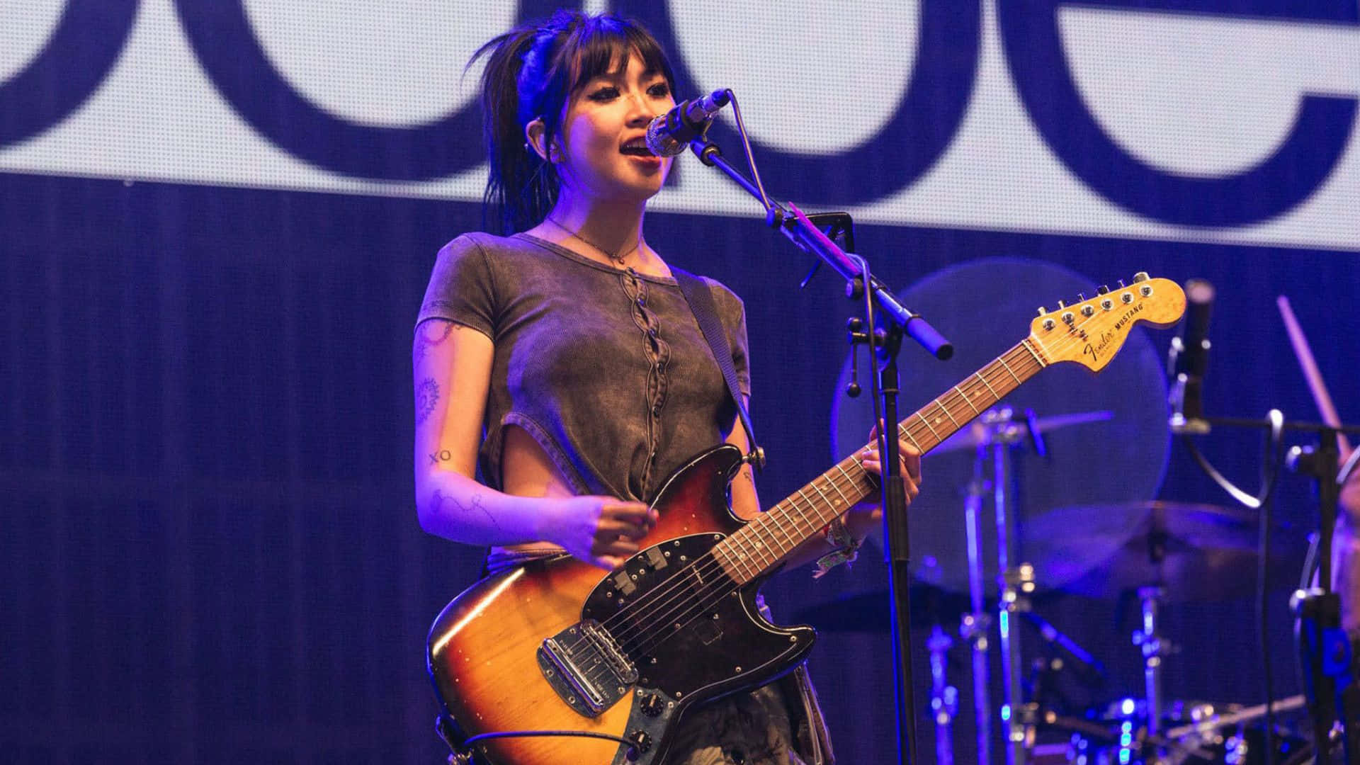 Beabadoobee, sunburst Fender electric guitar, blue-lit stage, Full HD Desktop Wallpaper