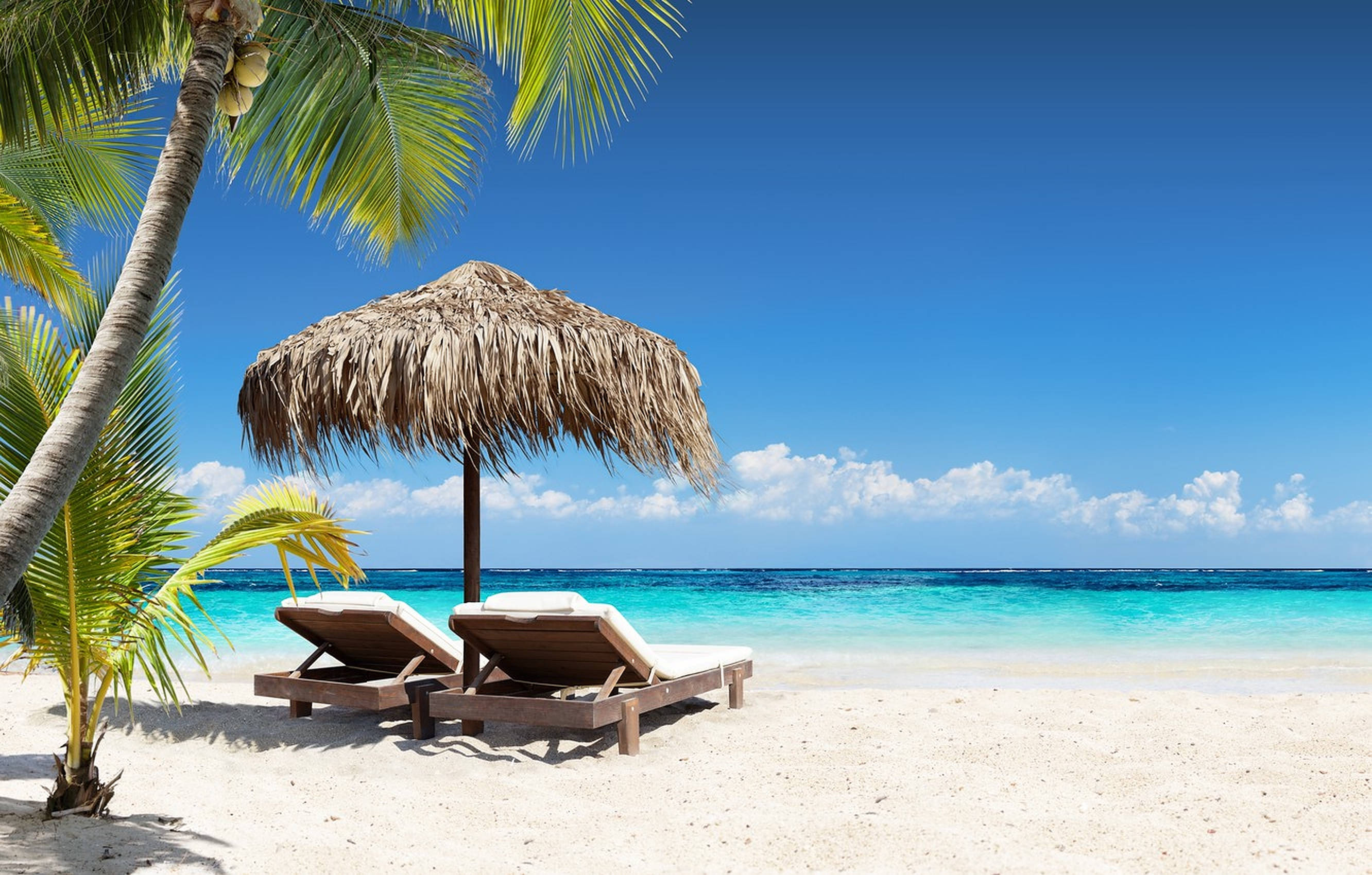 wooden lounge chairs, thatched umbrella, pristine white sand beach, 2K Desktop Wallpaper