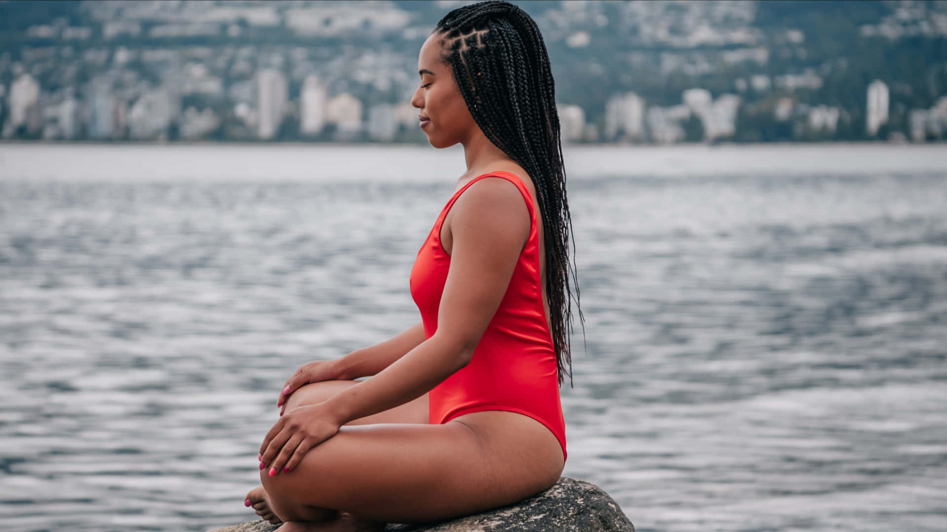 vibrant red swimsuit, rock by the water, cityscape in the background, Full HD Desktop Wallpaper