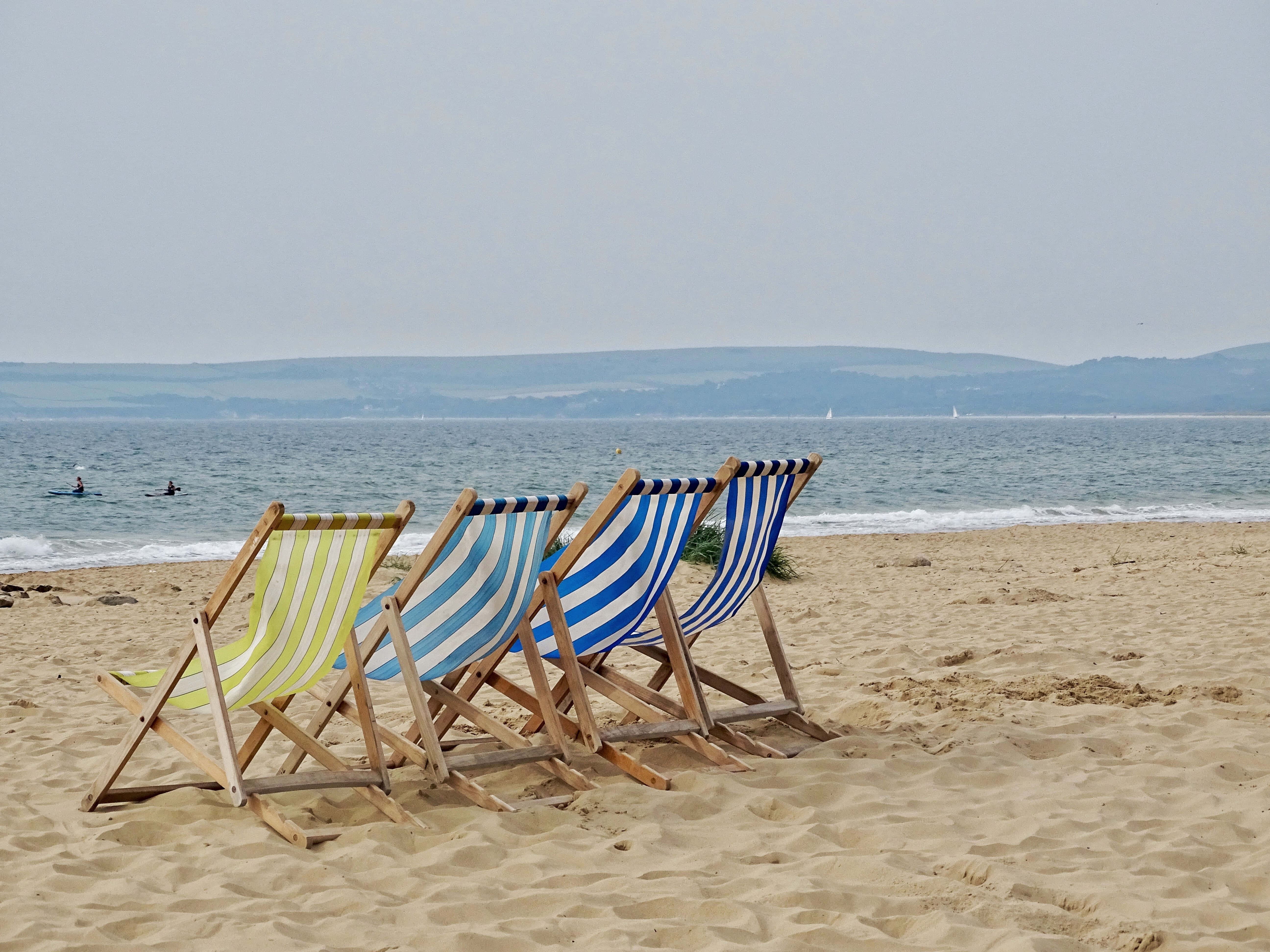 striped deck chairs, sandy beach, calm sea, 5K Desktop Wallpaper